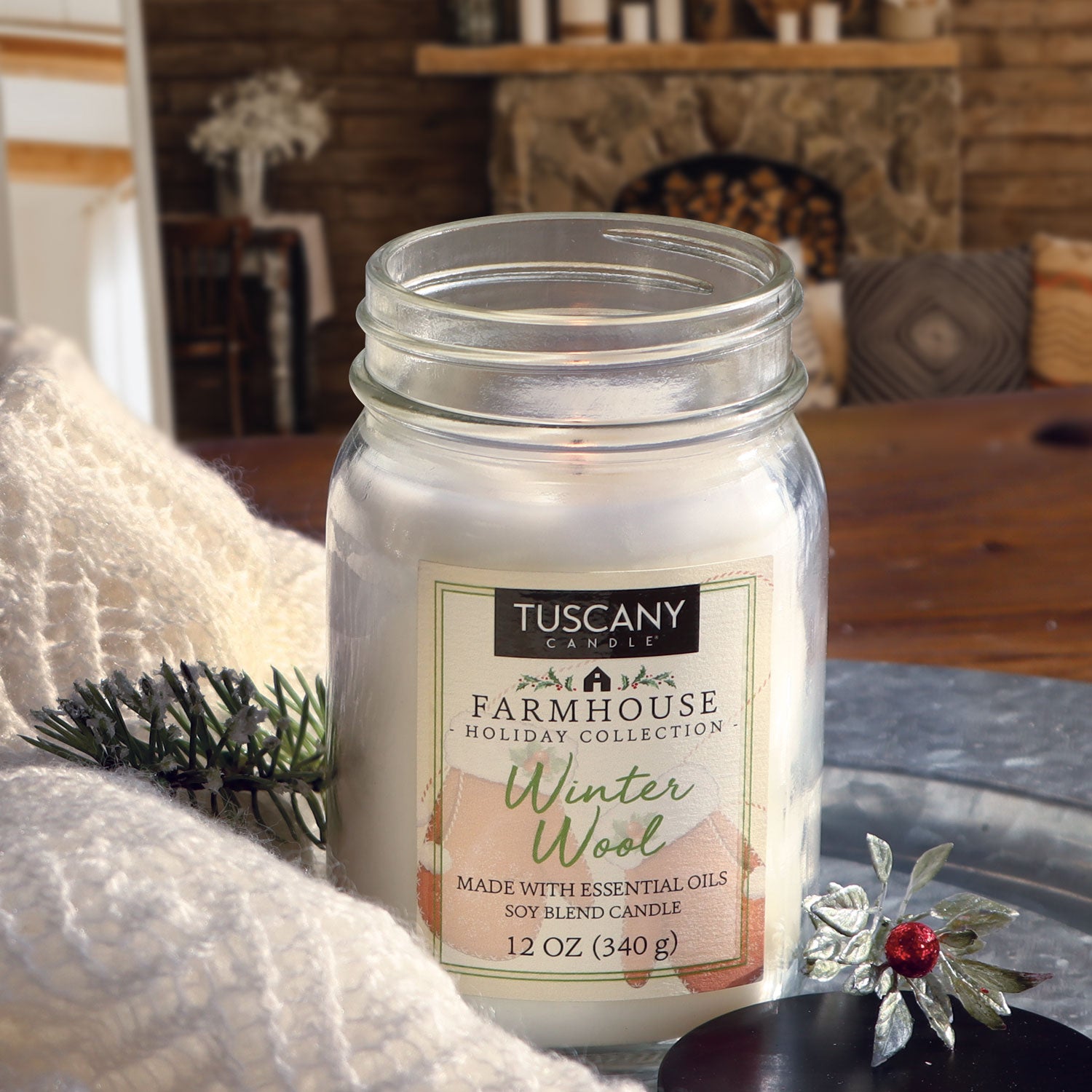Our Winter Wool Christmas candle is shown nestled amongst some wool blankets in front of a fireplace
