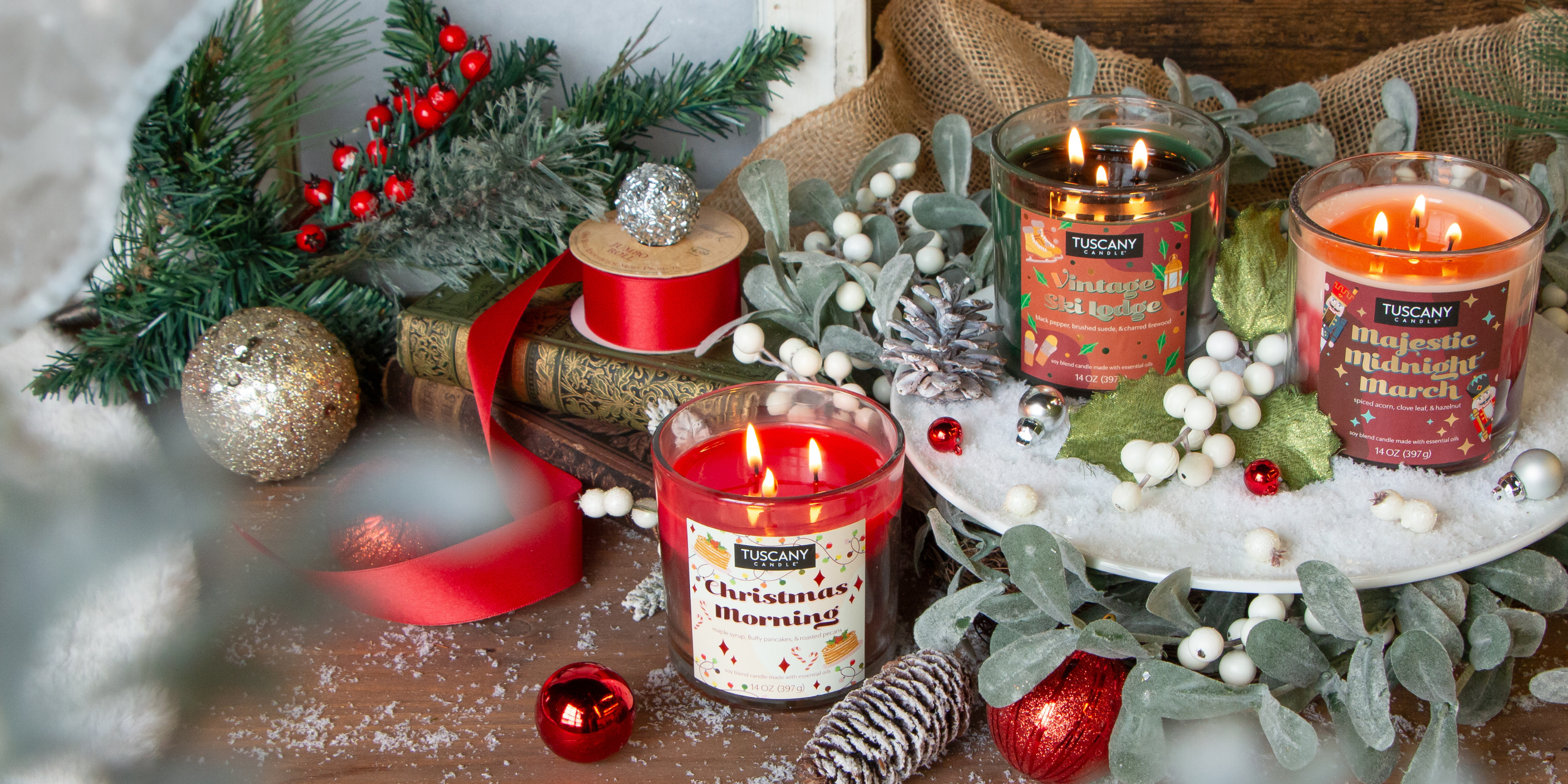 Three holiday-themed candles are displayed on a festive table with ornaments, pine branches, and ribbon. Text reads: "CHRISTMAS IN JULY: SAVE 35% OFF. Your fave holiday scents are back.