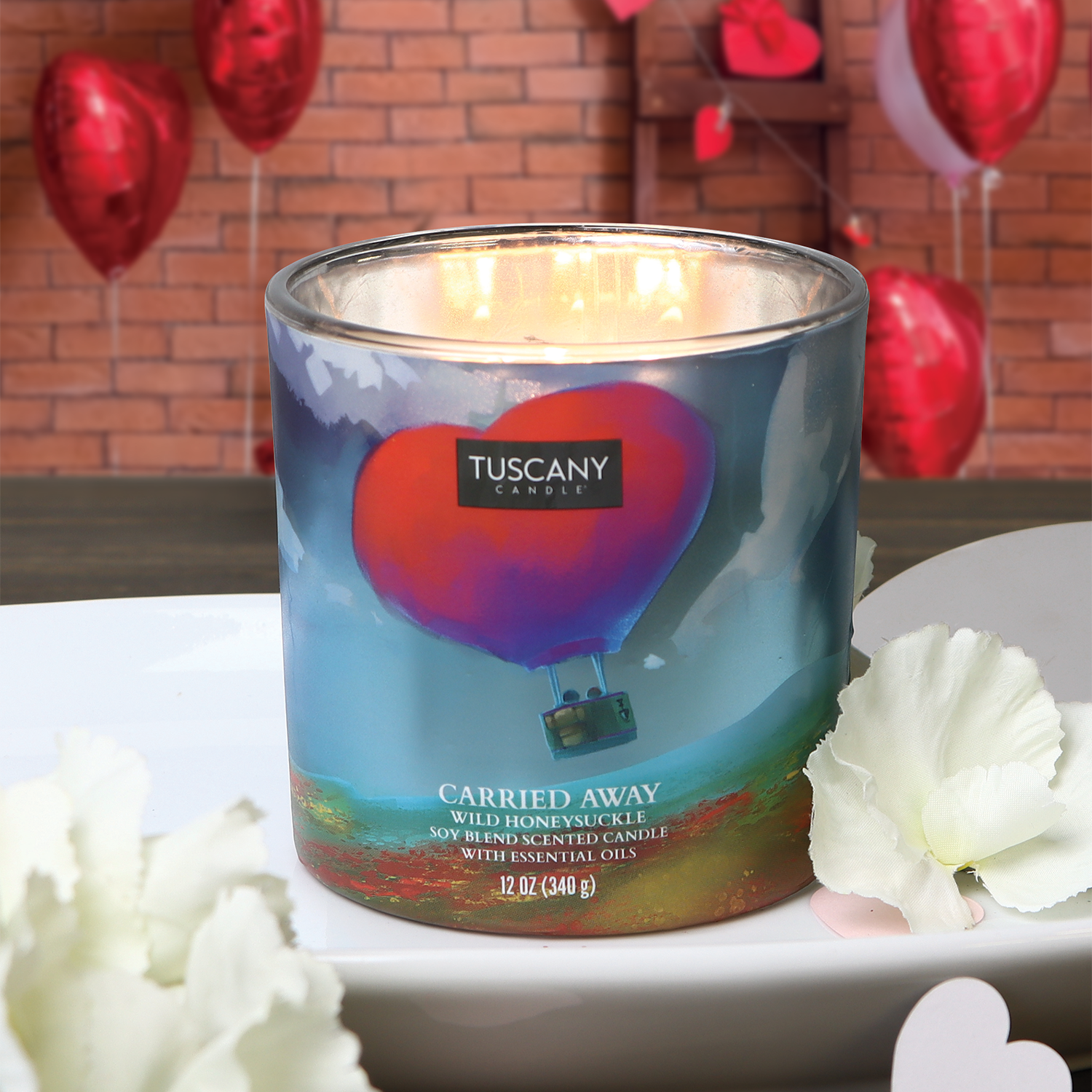 A Tuscany Candle® SEASONAL Carried Away Scented Jar Candle (12 oz) – Carried Away Collection on a plate.