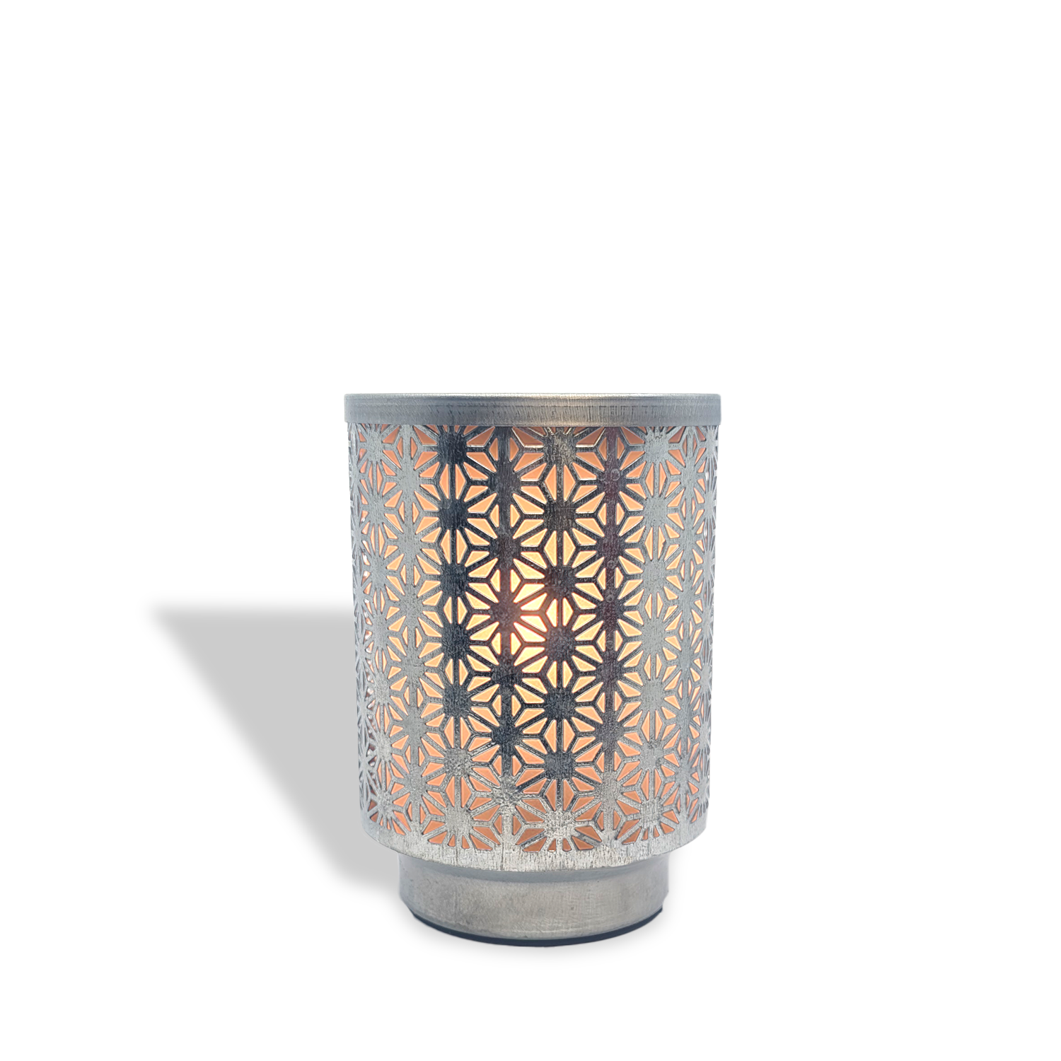 The Tuscany Candle® Everyday Galvanized Metal Outlet Wax Melt Warmer features a geometric cutout design that emits warm light and casts intricate shadows on any white background.