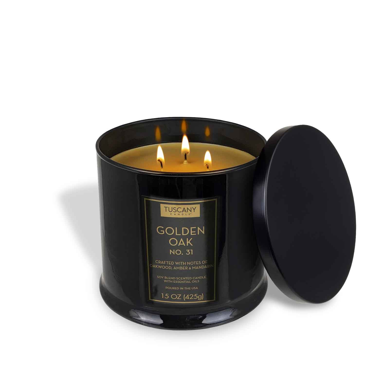 A sleek black glass jar candle, Tuscany Candle® EVD’s Golden Oak Scented Jar Candle (15 oz) from the Homme + Heritage Collection, features three lit wicks and a black lid to the side, infusing the air with its signature aroma.