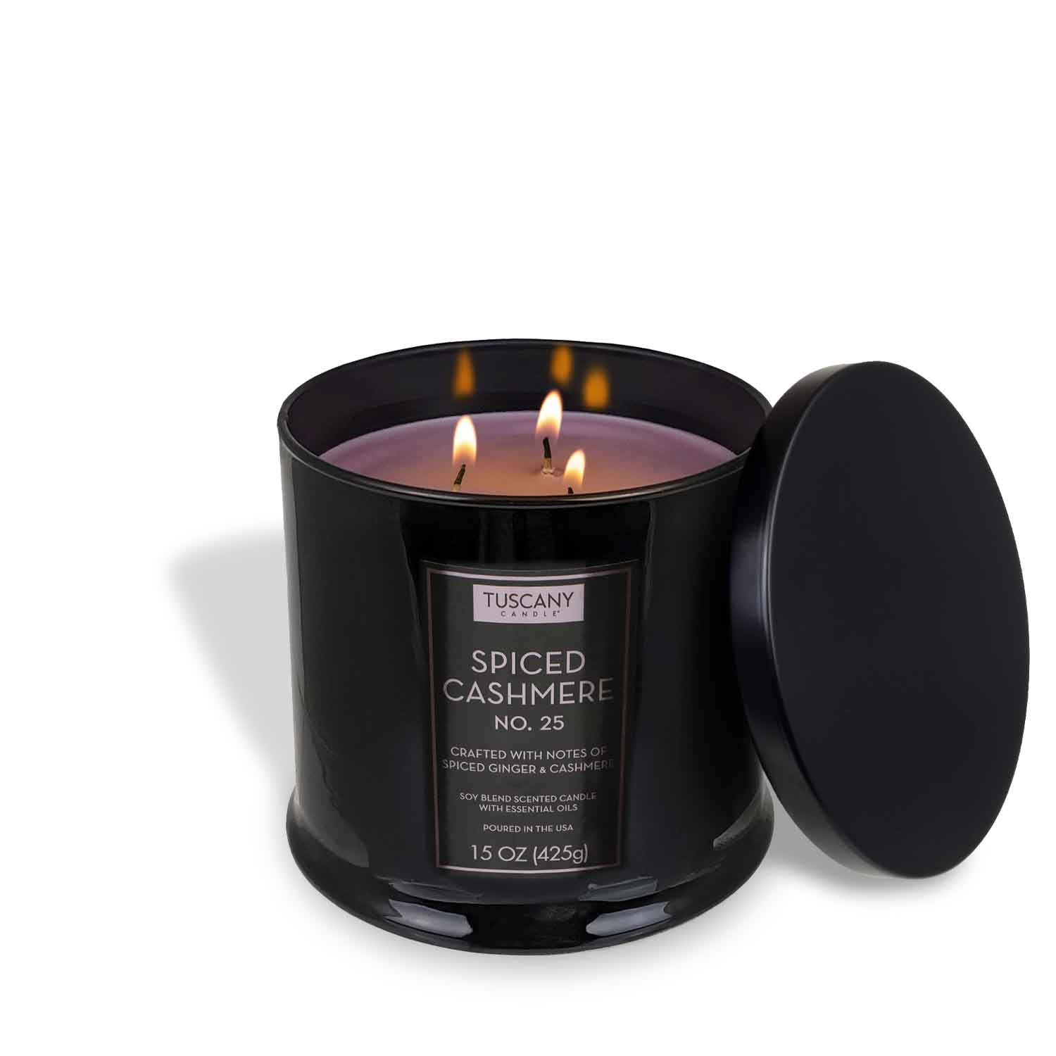 The Tuscany Candle® EVD Spiced Cashmere Scented Jar Candle (15 oz) from the Homme + Heritage Collection features three lit wicks in a black glass jar with the lid beside it, creating a warm, masculine ambience.