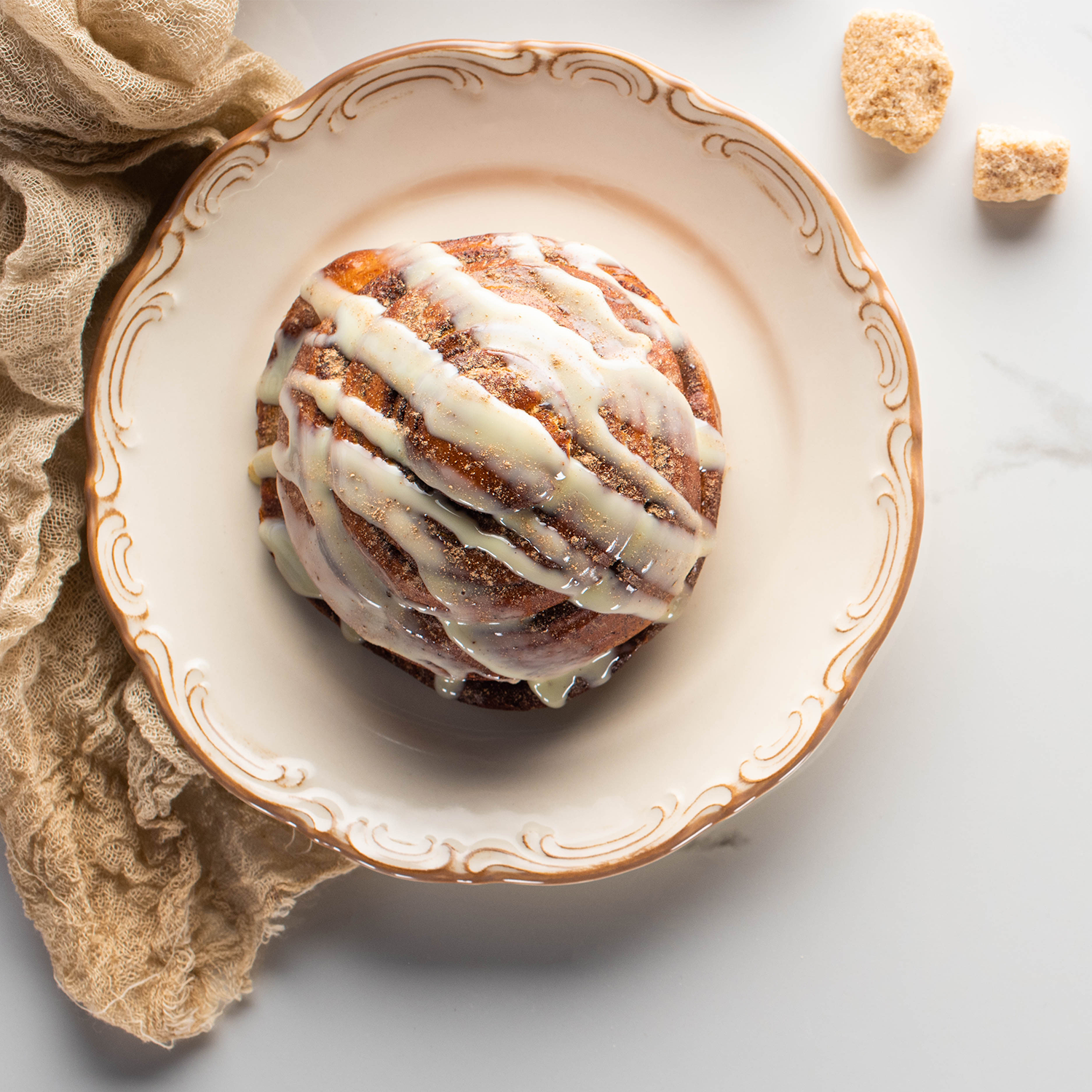 Product Description: Indulge in the delectable delight of a freshly baked cinnamon roll. This irresistible treat features a perfect balance of warm, gooey cinnamon goodness swirled within soft, fluffy Dessert For Two Long-Lasting Scented Jar Candle (14 oz) from Tuscany Candle® SEASONAL.