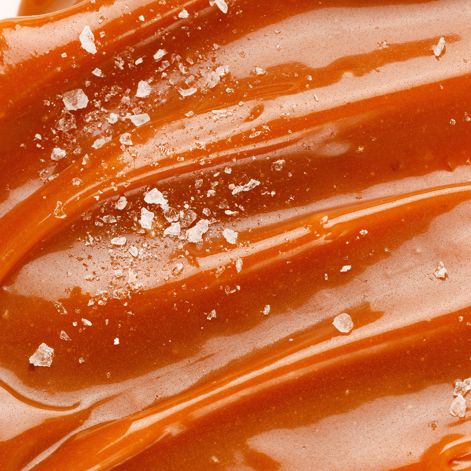 Close-up of the Ginger Lemon Pumpkin Long-Lasting Scented Jar Candle (12 oz) from Tuscany Candle® SEASONAL, Copper Harvest Collection, showcasing smooth caramel tones drizzled with coarse sea salt crystals and enhanced by a hint of spicy ginger.