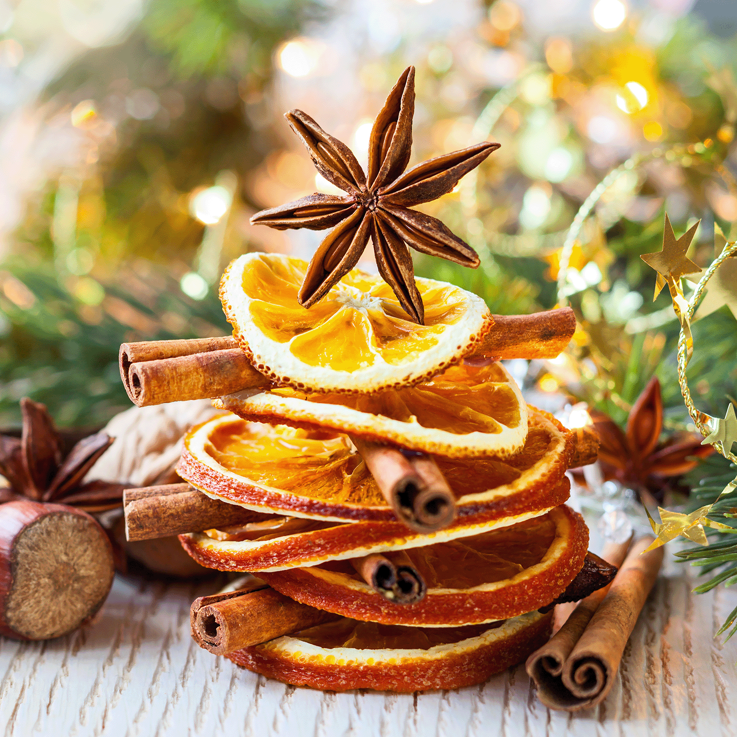 Stack of apple spice-scented wax melts, accented with cinnamon sticks and a star anise, arranged in a festive holiday decor setting by Tuscany Candle® SEASONAL.