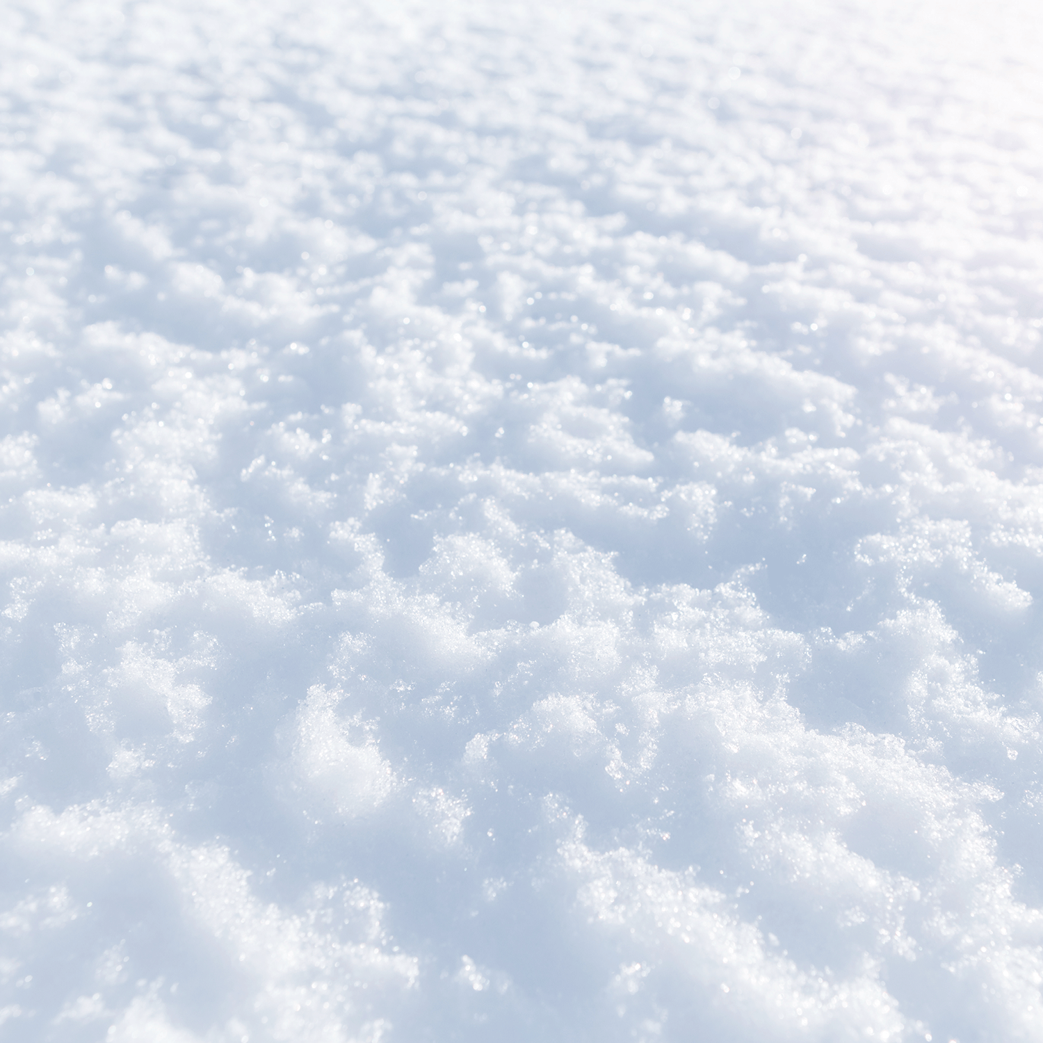 A close-up of the snow-inspired surface of the "In The Lane Snow is Glistening" scented jar candle by Tuscany Candle® SEASONAL, capturing the essence of a wintry scent in its textured, crystalline wax under soft lighting.