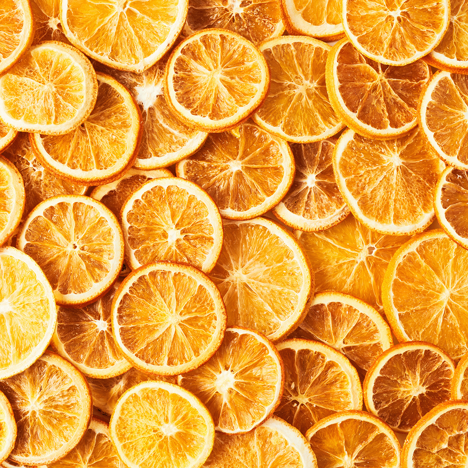 A close-up of many dried orange slices overlapping, evoking the warm fragrance of Tuscany Candle® SEASONAL Fall Festival: Cinnamon & Clove Scented Fall Wax Melt (2.5 oz).