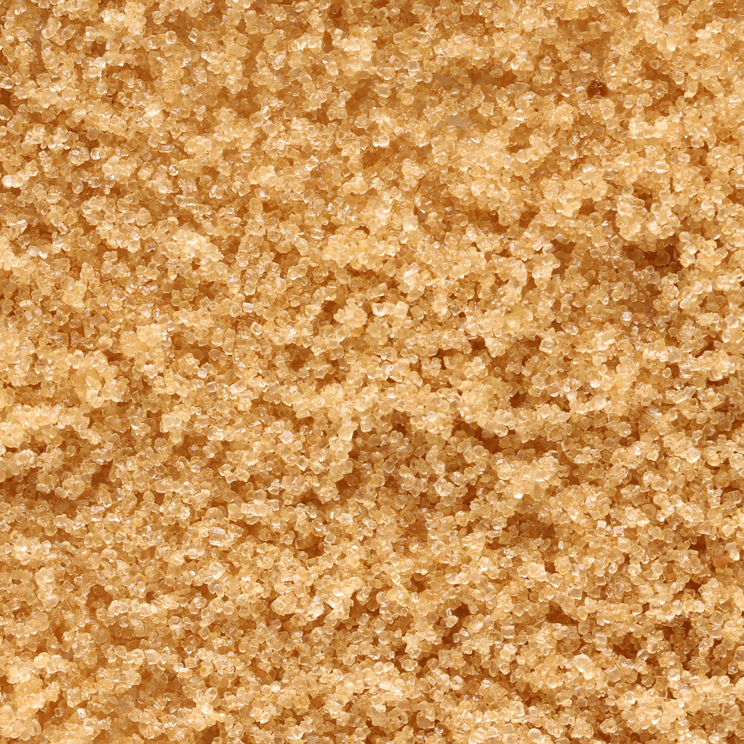 A close-up of coarse brown sugar crystals, ideal for capturing the warm, inviting aroma of Tuscany Candle® SEASONAL's Ginger Carrot Cake: Spice Cake & Sugar Scented Fall Candle (12 oz), part of the Bakery Tins Collection.