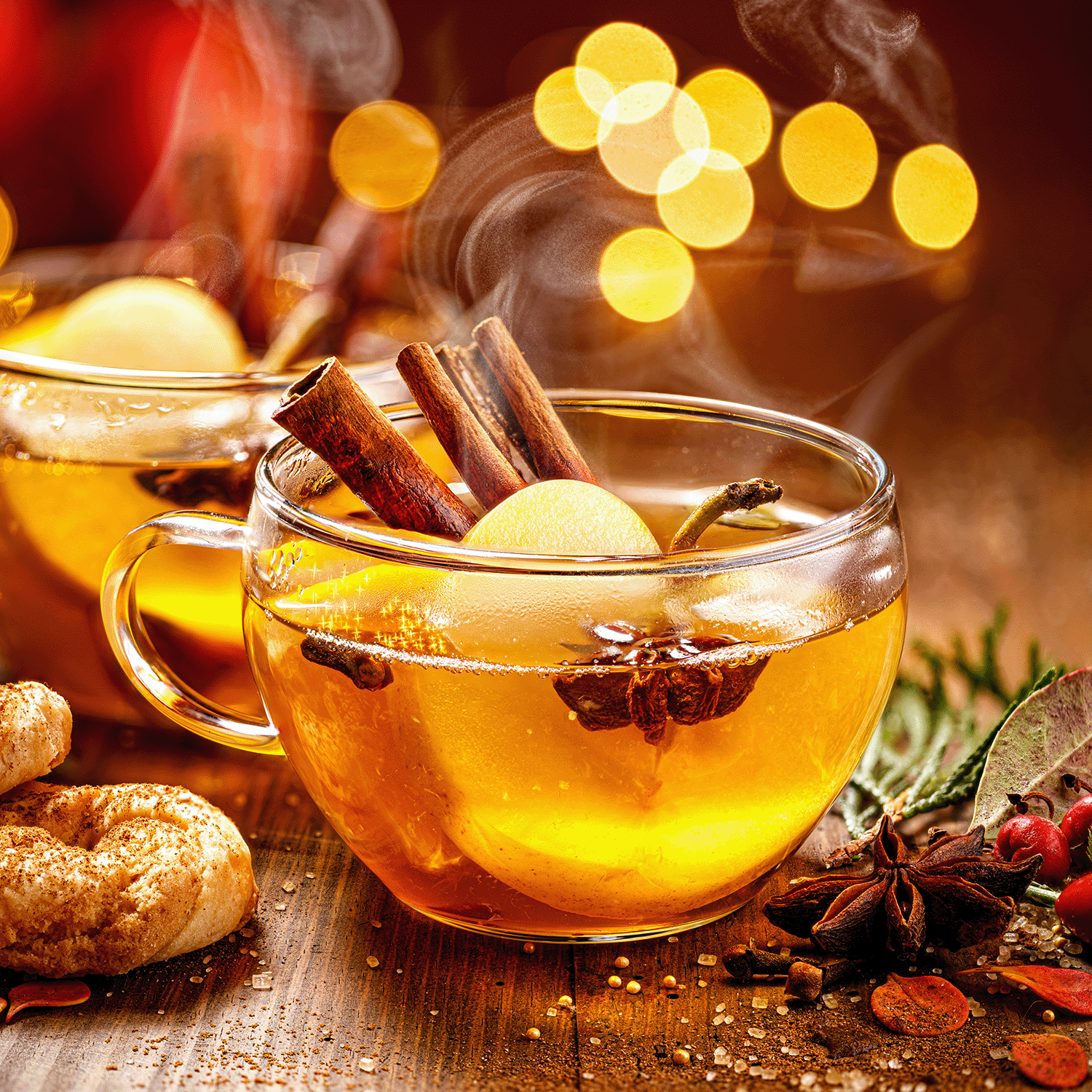 A warm, festive scene with spiced tea, cookies, and cozy decor surrounds the Reindeer Reins: Aged Leather & Pine Scented Holiday Wax Melt (2.5 oz) by Tuscany Candle® SEASONAL, evoking the comforting aroma of winter.