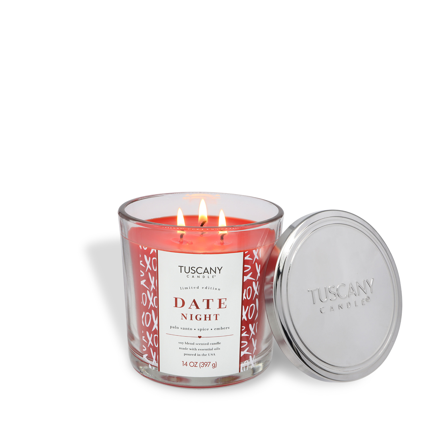 A Tuscany Candle® SEASONAL "Date Night: Palo Santo Scented Valentine's Candle" (14 oz) burns with three flames in a glass jar, its silver lid resting nearby.