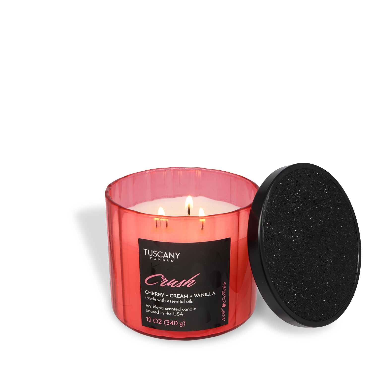 A Tuscany Candle® SEASONAL "Crush: Cherries & Cream Scented Valentine's Candle" (12 oz) with three lit wicks sits beside its black lid on a white background.