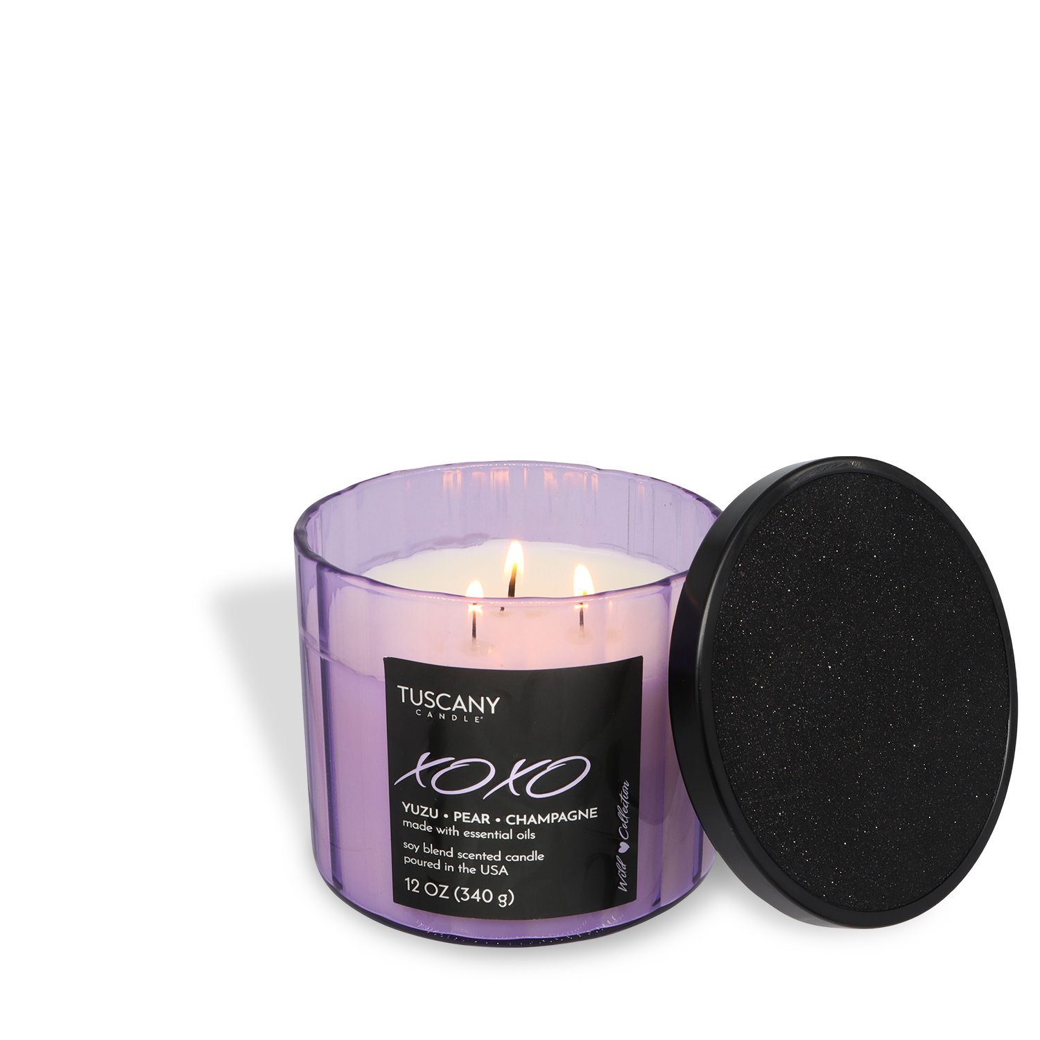A lit Tuscany Candle® SEASONAL XOXO: Yuzu & Champagne Scented Valentine's Candle (12 oz) in a purple glass container with a black lid beside it.