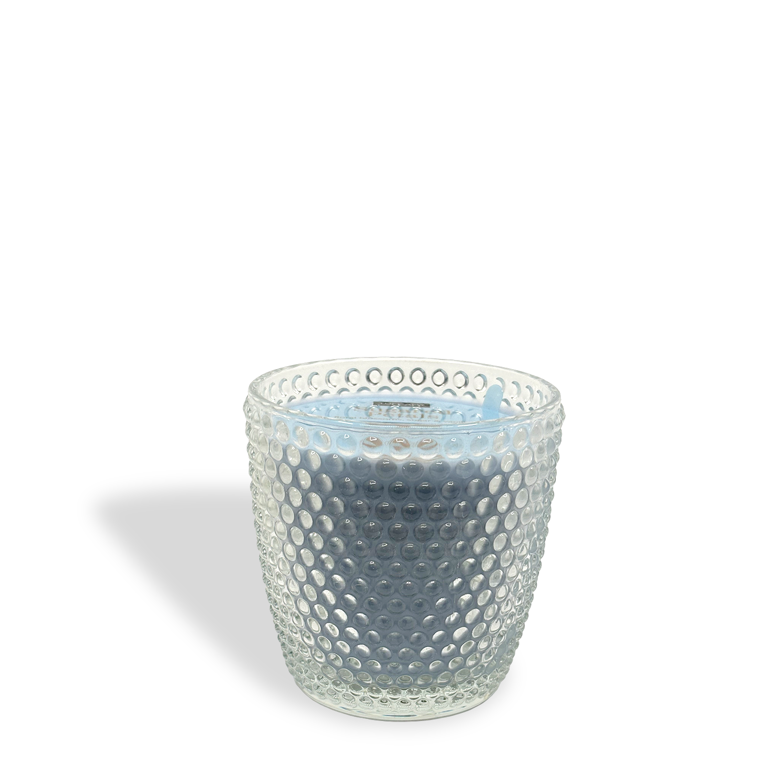 The Tuscany Candle® Sugared Petals: Floral Blossoms & Sugar Scented Easter Candle (8.5 oz) sits in a textured clear glass container, casting a shadow on a white background.