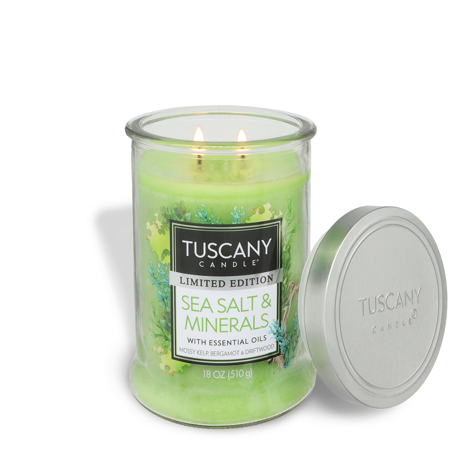 A lit Tuscany Candle® SEASONAL Sea Salt & Minerals: Mossy Kelp & Driftwood Scented Spring Candle (18 oz) in a glass jar, ideal for coastal decor, with a silver lid placed beside it.