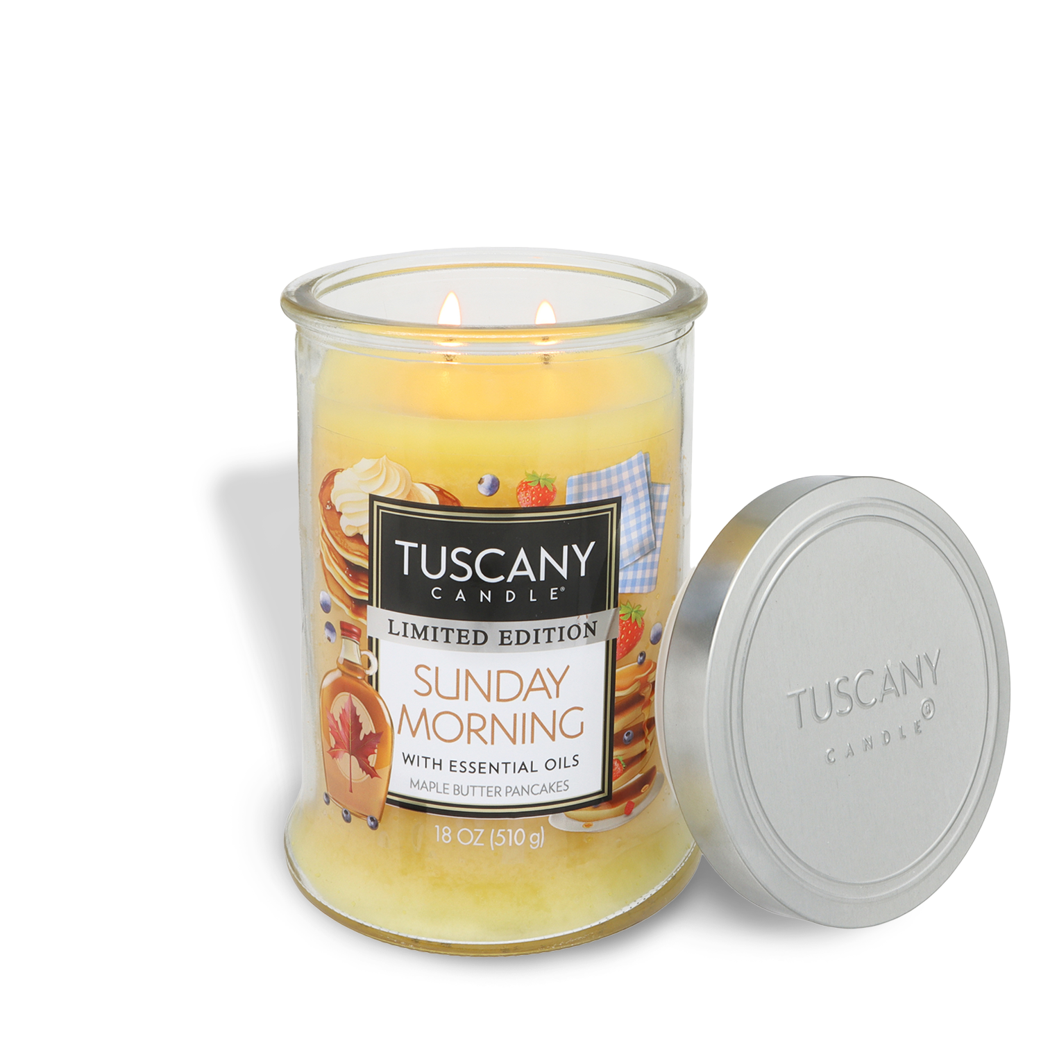 An 18 oz Tuscany Candle® SEASONAL "Sunday Morning: Maple Butter Pancakes Scented Spring Candle" is shown lit in its glass jar, with the silver lid placed beside it.