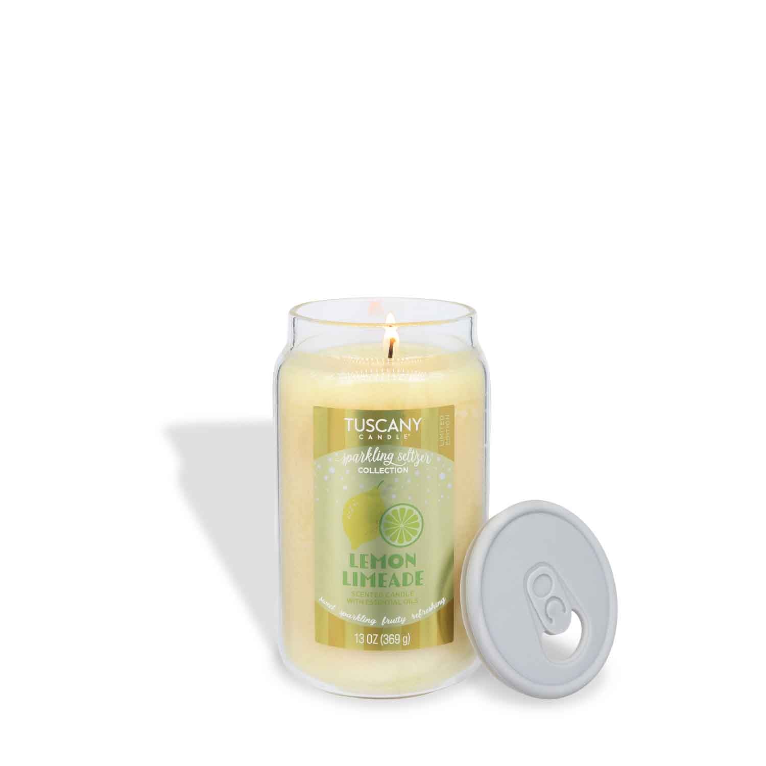 A lit Tuscany Candle® SEASONAL "Lemon Limeade: Sparkling Seltzer Scented Summer Candle" (13 oz) in a clear glass jar with a gray lid sits on a white background.