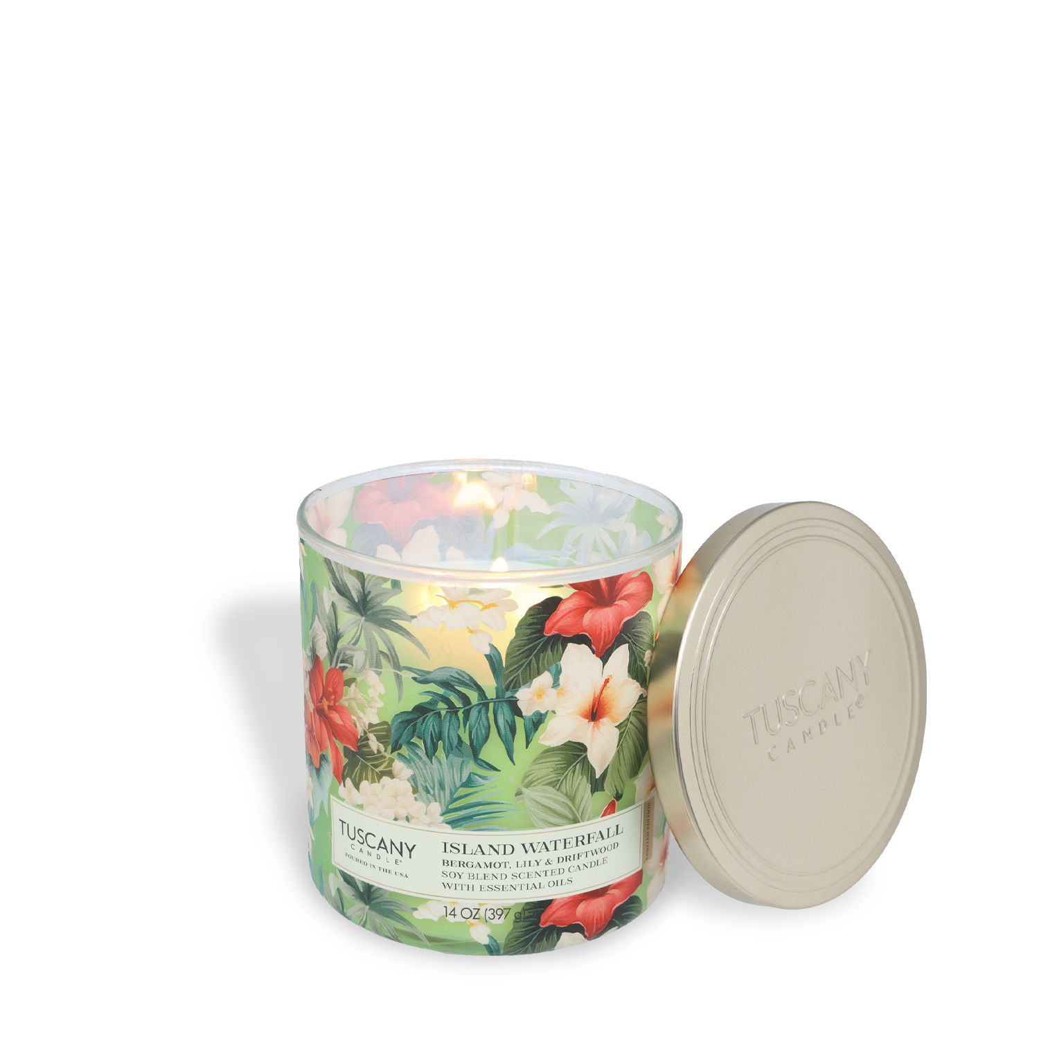 A lit Tuscany Candle® SEASONAL "Island Waterfall: Bergamot & Lily Scented Spring Candle" (14 oz) from the Dreamy Destinations Collection features a tropical floral design and an off-white lid set beside it.