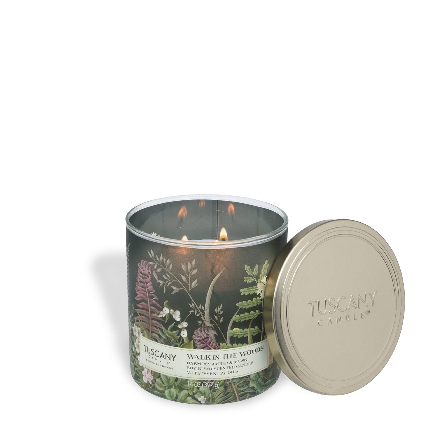 A lit Tuscany Candle® SEASONAL "Walk In The Woods: Oakmoss & Amber" 14 oz scented candle from the Dreamy Destinations Collection fills the air with fresh, woodsy vibes; its floral-decorated container sits open with the lid beside it.