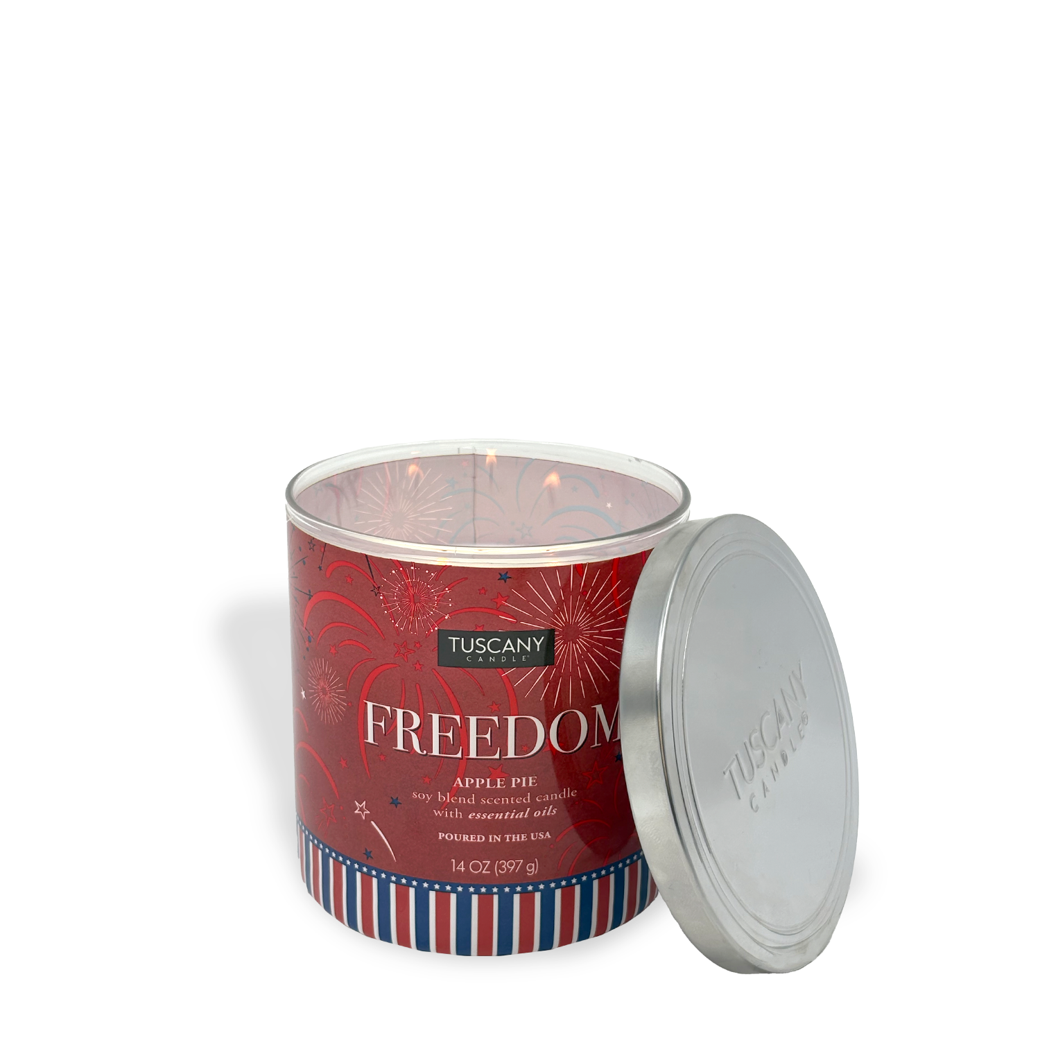 A Tuscany Candle® SEASONAL "Freedom: Apple Pie Scented Summer Candle" (14 oz) with a fireworks label and open silver lid sits nearby, showing the partially melted wax inside.