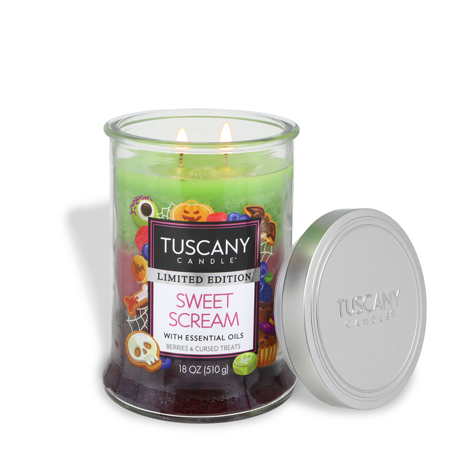 A Tuscany Candle® SEASONAL “Sweet Scream: Berries & Cursed Treats” Halloween candle (18 oz) with festive graphics, two wicks aglow, a silver lid resting against the jar, and vibrant green and purple wax.
