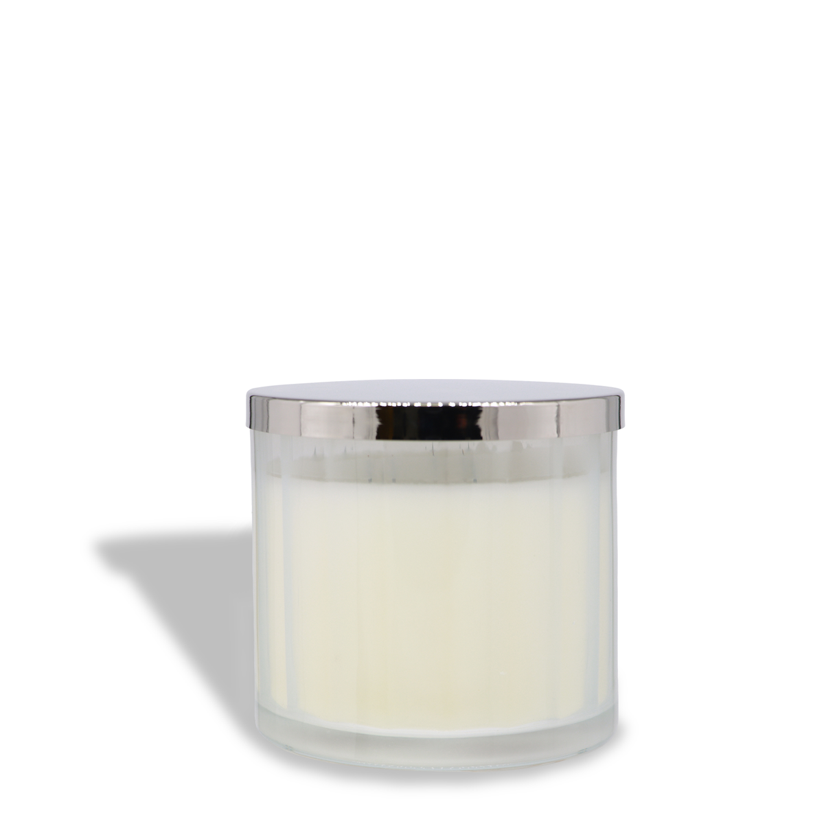 The Haunted Hearth: Apple & Citrus Zest Scented Halloween Candle (12.5 oz) by Tuscany Candle® SEASONAL features a white candle in a clear glass container with a silver metal lid, casting a shadow to the left on a white background.