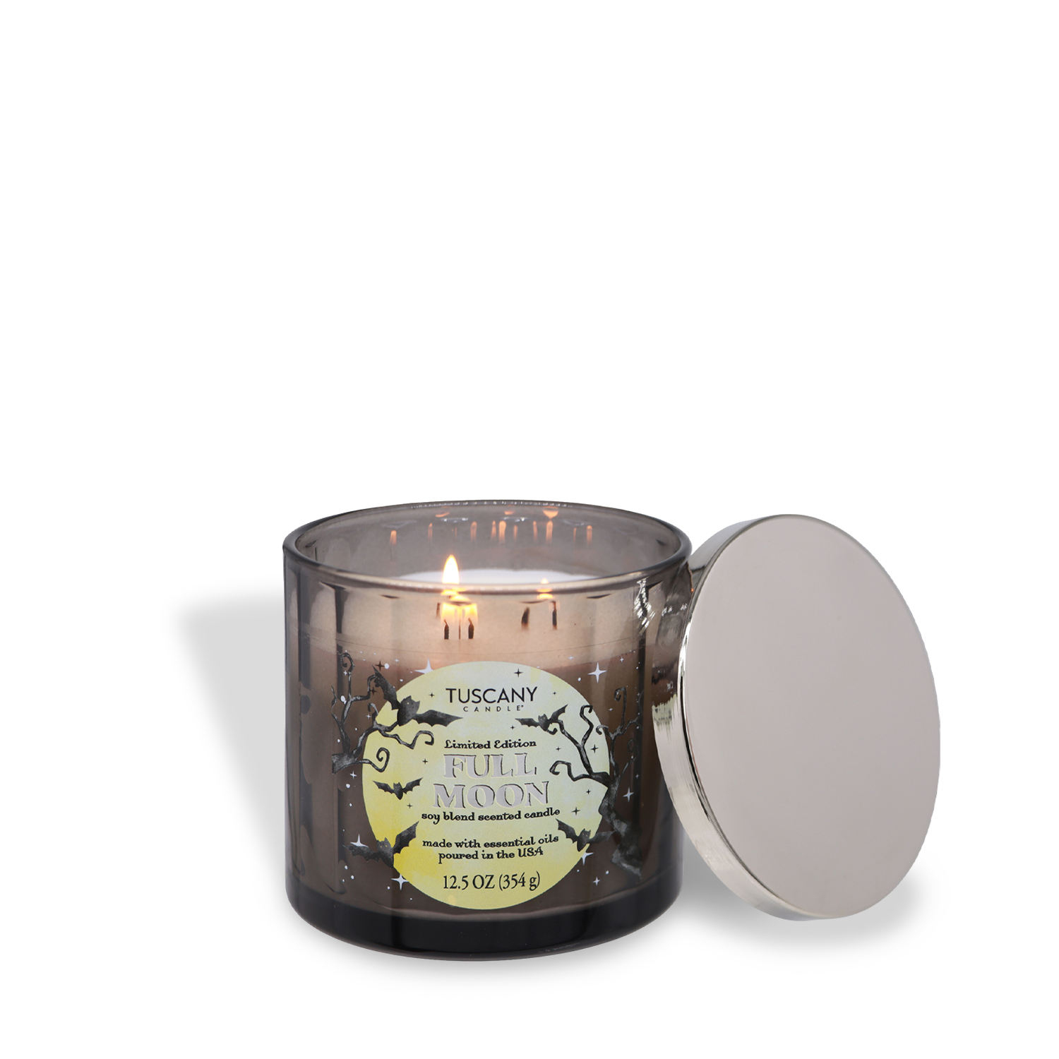 A gray glass candle labeled “Full Moon: Black Timber & Red Cherry” by Tuscany Candle® SEASONAL, with three lit wicks and a silver lid resting to the side.