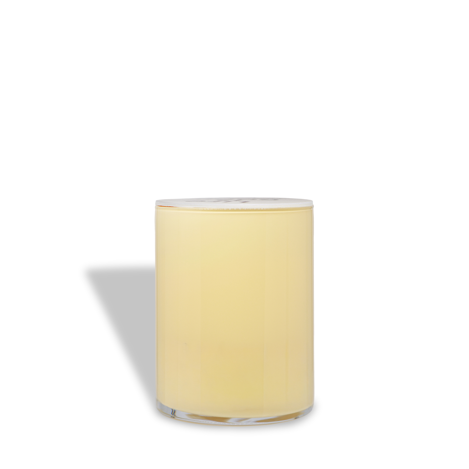 A Life Is Good® Vanilla Pumpkin Scented Halloween Candle (13 oz) by Tuscany Candle® SEASONAL, featuring a yellow candle in a clear glass container with a white lid, casts a shadow to the left on a white background.