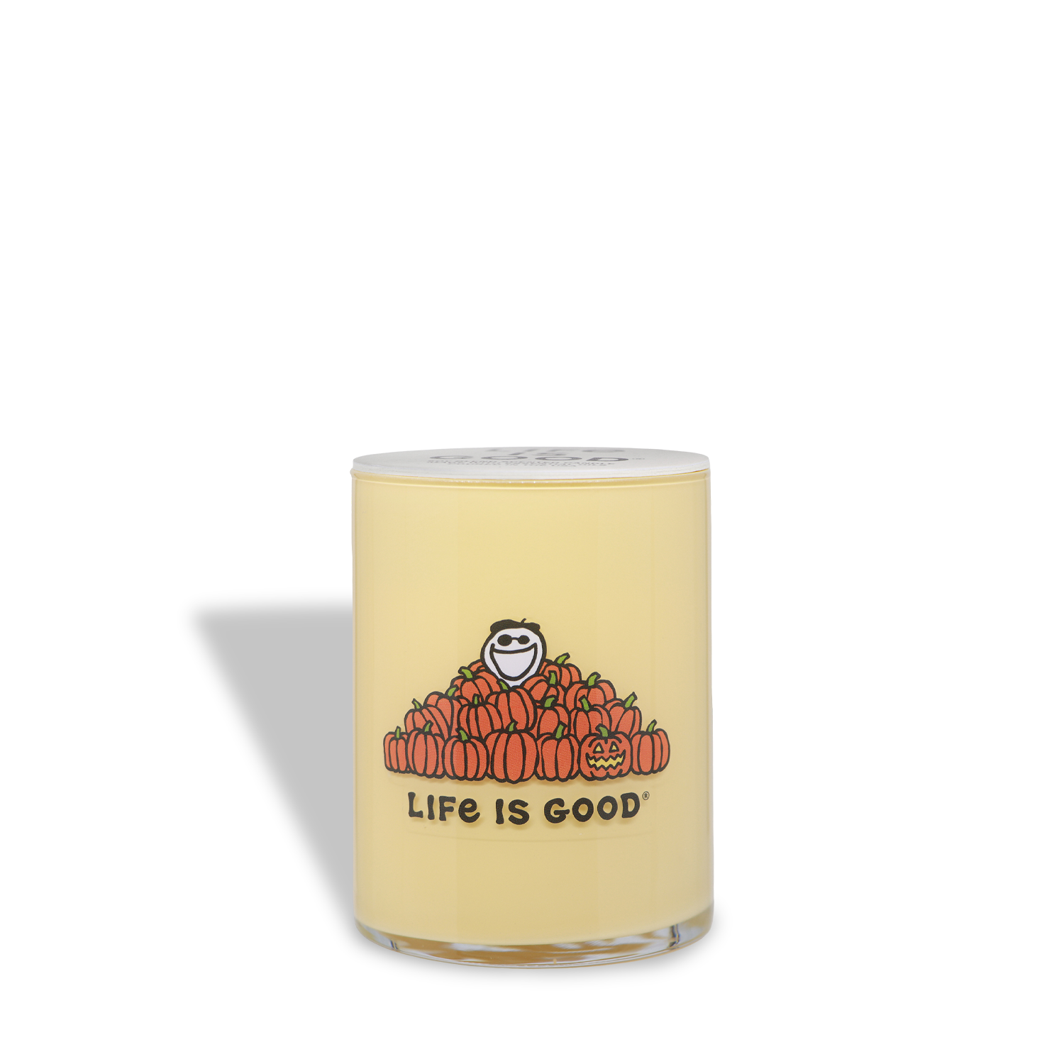 A 13 oz yellow vanilla pumpkin scented Halloween candle from Tuscany Candle® SEASONAL, in a glass jar with a “Life Is Good” logo featuring a smiling figure sitting on pumpkins.