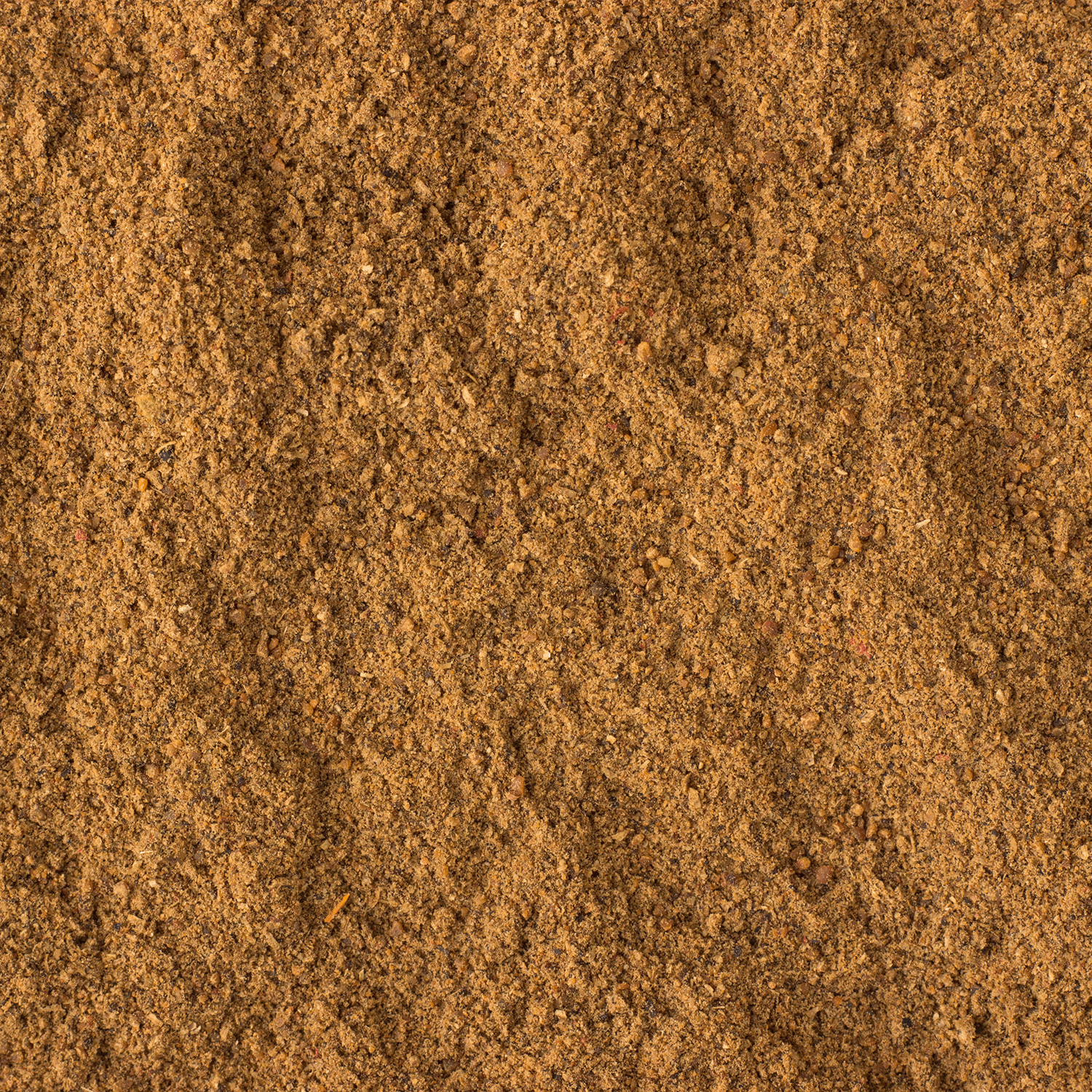 A close-up view of a rich brown, finely ground powder spread evenly across the frame, evoking the cozy and inviting aroma of Tuscany Candle® SEASONAL's Salted Maple Chai: Cream & Cinnamon Scented Fall Candle (14 oz), reminiscent of autumn home fragrance.
