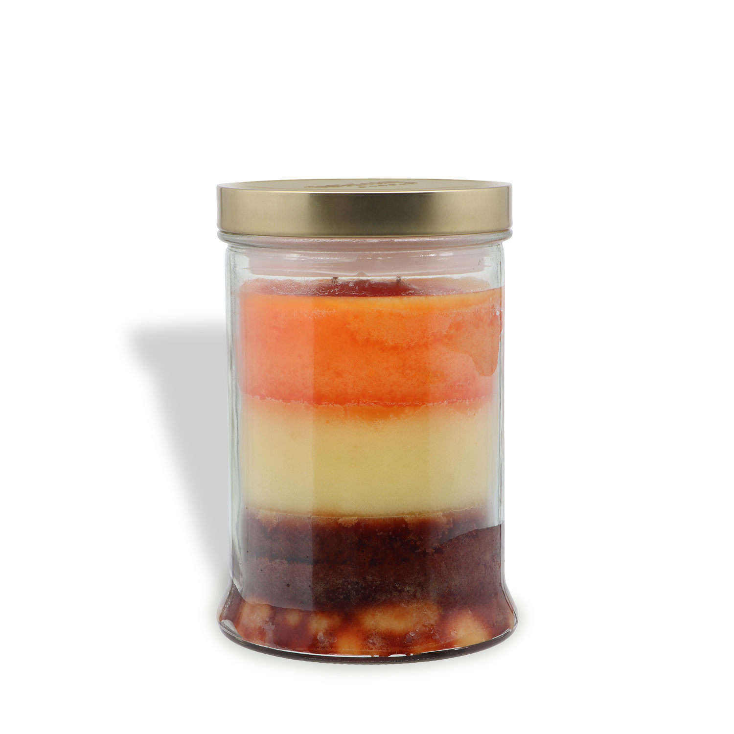 A clear glass jar with a gold lid holds the Tuscany Candle® SEASONAL "Maple Pumpkin: Buttered Pancake Scented Fall Candle" (18 oz), featuring four colorful layers in red, orange, yellow, and brown.