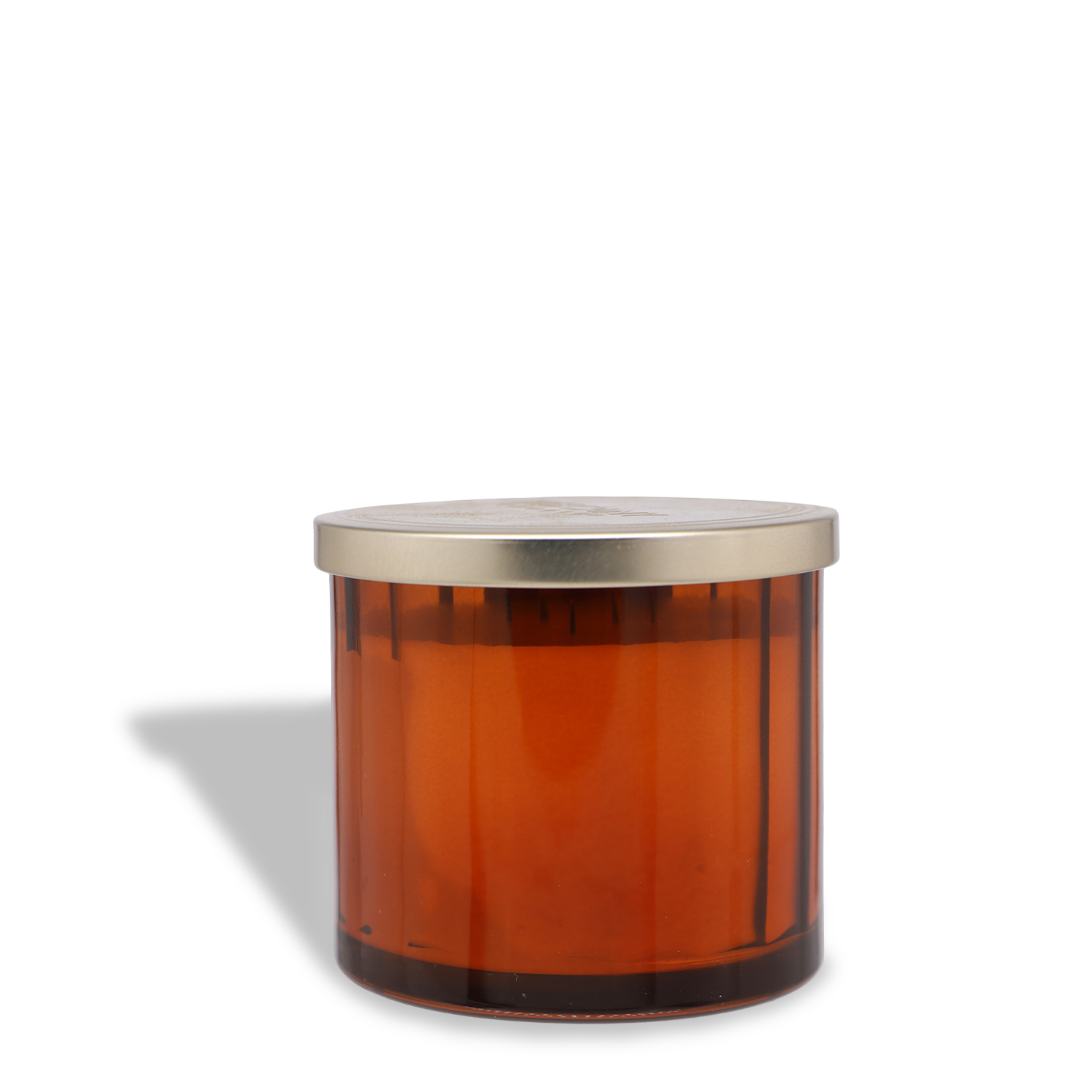 A Cinnamon Bun: Icing & Dough Scented Fall Candle (12.5 oz) by Tuscany Candle® SEASONAL sits in a brown glass jar with a silver lid, casting a left shadow on white; it's crafted from soy blend wax.