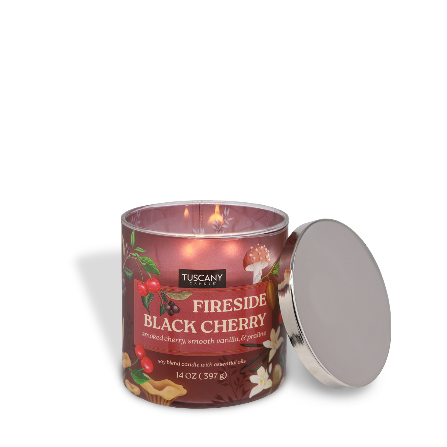 A lit Tuscany Candle® SEASONAL "Fireside Black Cherry: Vanilla & Praline Scented Fall Candle" (14 oz) sits with its silver lid nearby, displaying images of cherries and vanilla on the label.