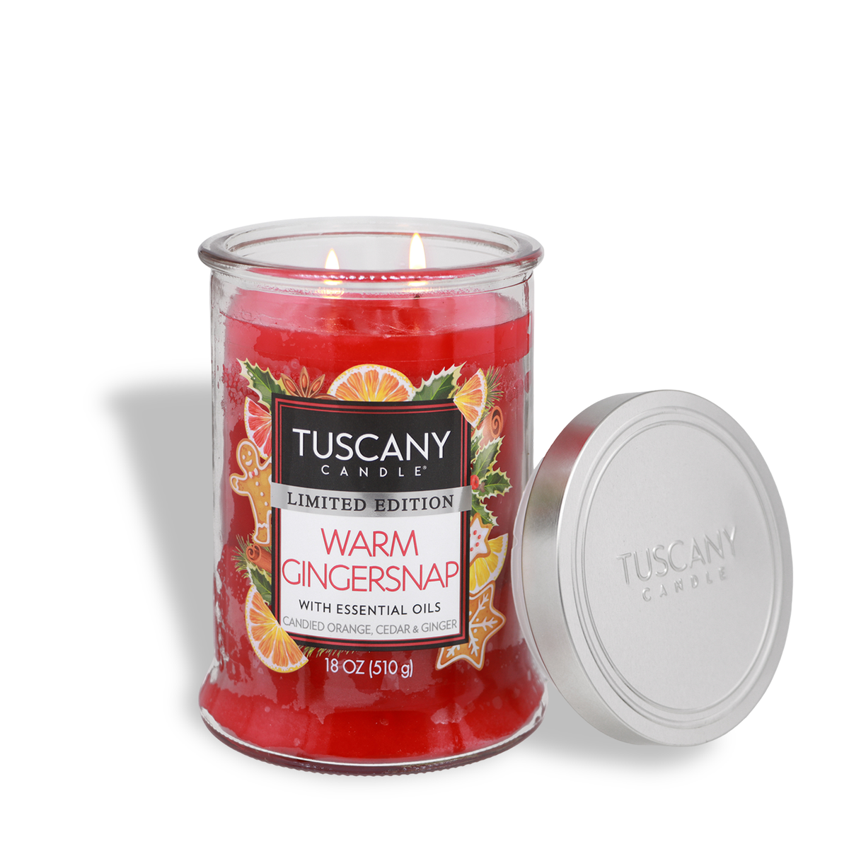 A red wax Tuscany Candle® SEASONAL Warm Gingersnap: Candied Orange & Cedar Scented Holiday Candle (18 oz) in a clear glass jar with a silver lid, featuring a label with gingerbread cookies and orange slices.