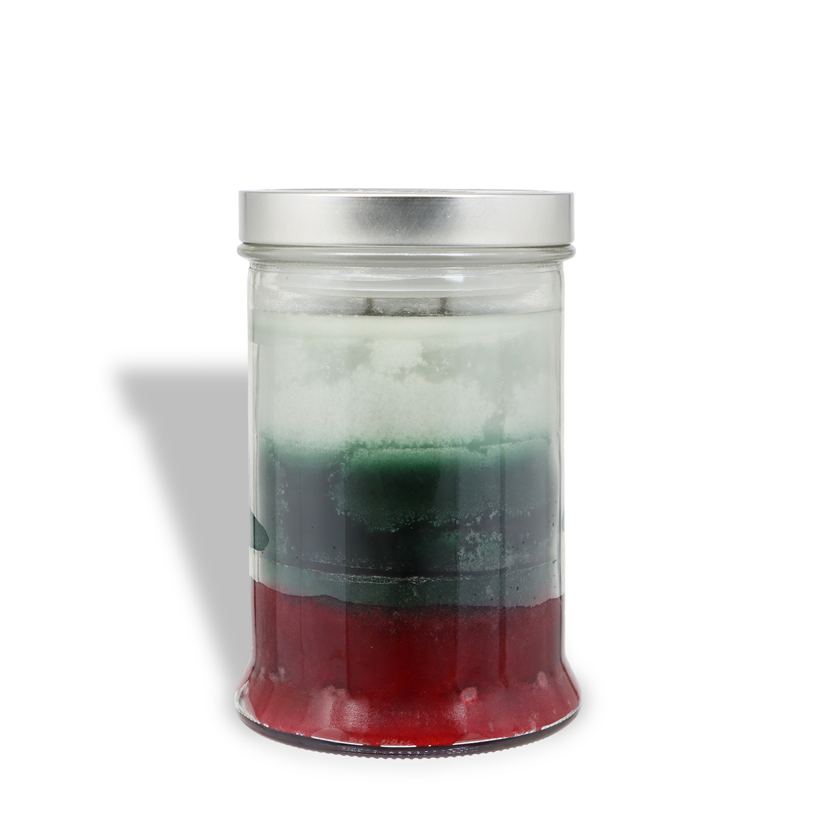 An Evening Fireside®: Sandalwood & Amber Scented Holiday Candle (18 oz) in a glass jar with layers of white, green, and red wax, topped with a silver lid.