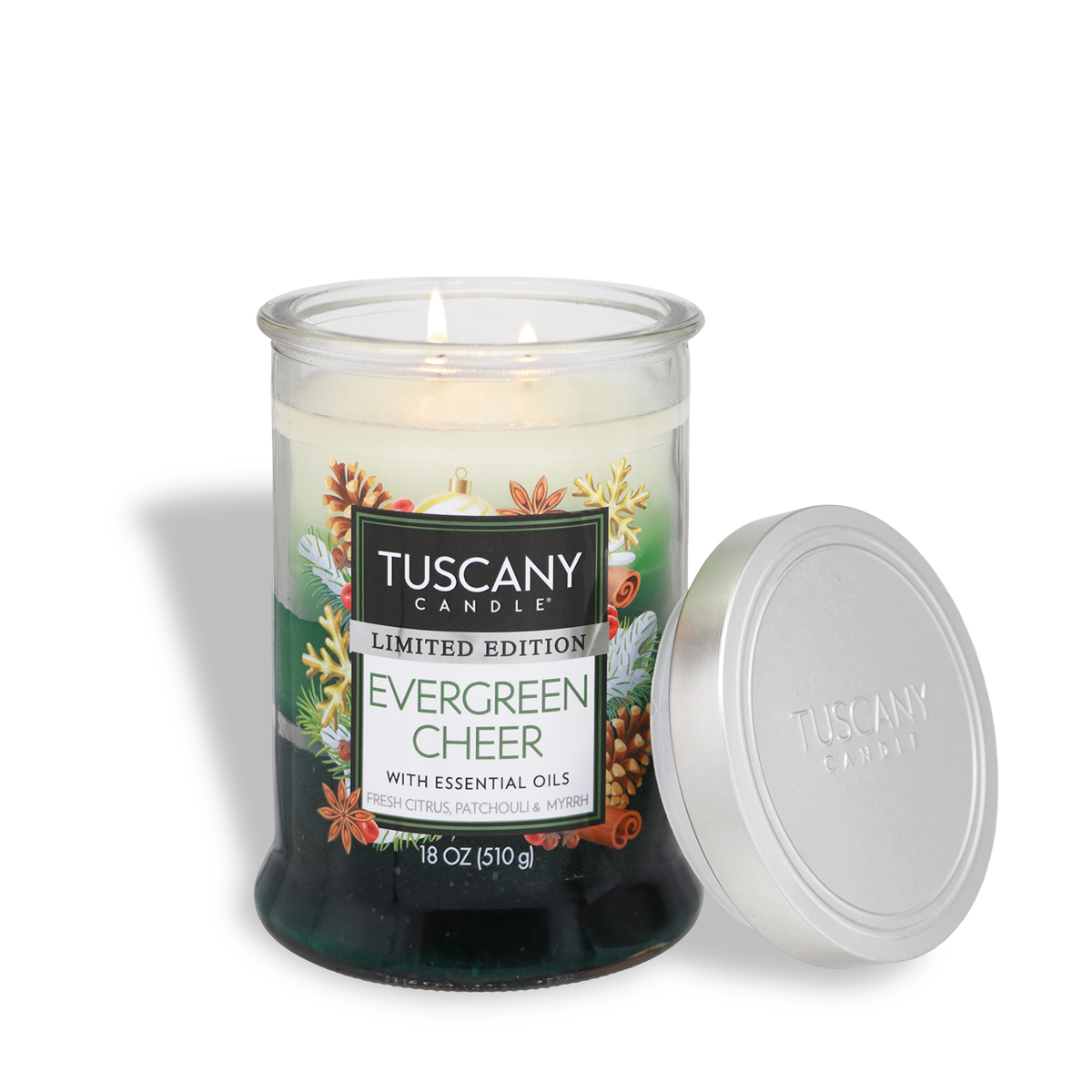 An 18 oz Evergreen Cheer: Fresh Citrus & Patchouli Scented Holiday Candle by Tuscany Candle® in a two-wick glass jar with green wax and a holiday label, shown with its silver lid removed.