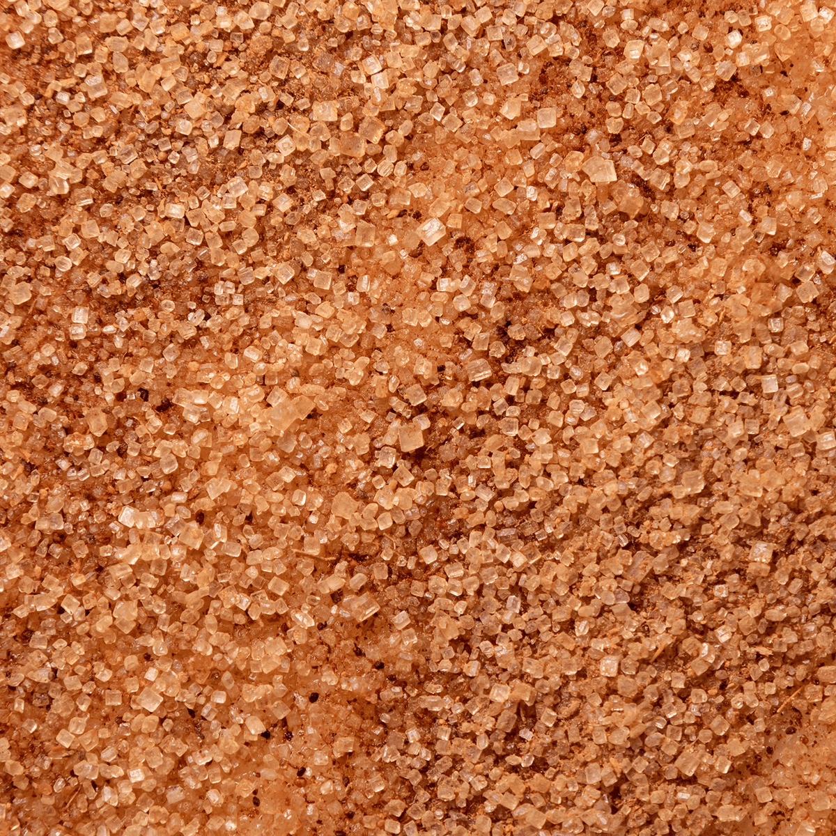 Close-up view of brown sugar crystals for a Cinnamon Spice: Warm Spice & Sugar Scented Holiday Candle (14 oz) by Tuscany Candle® SEASONAL.