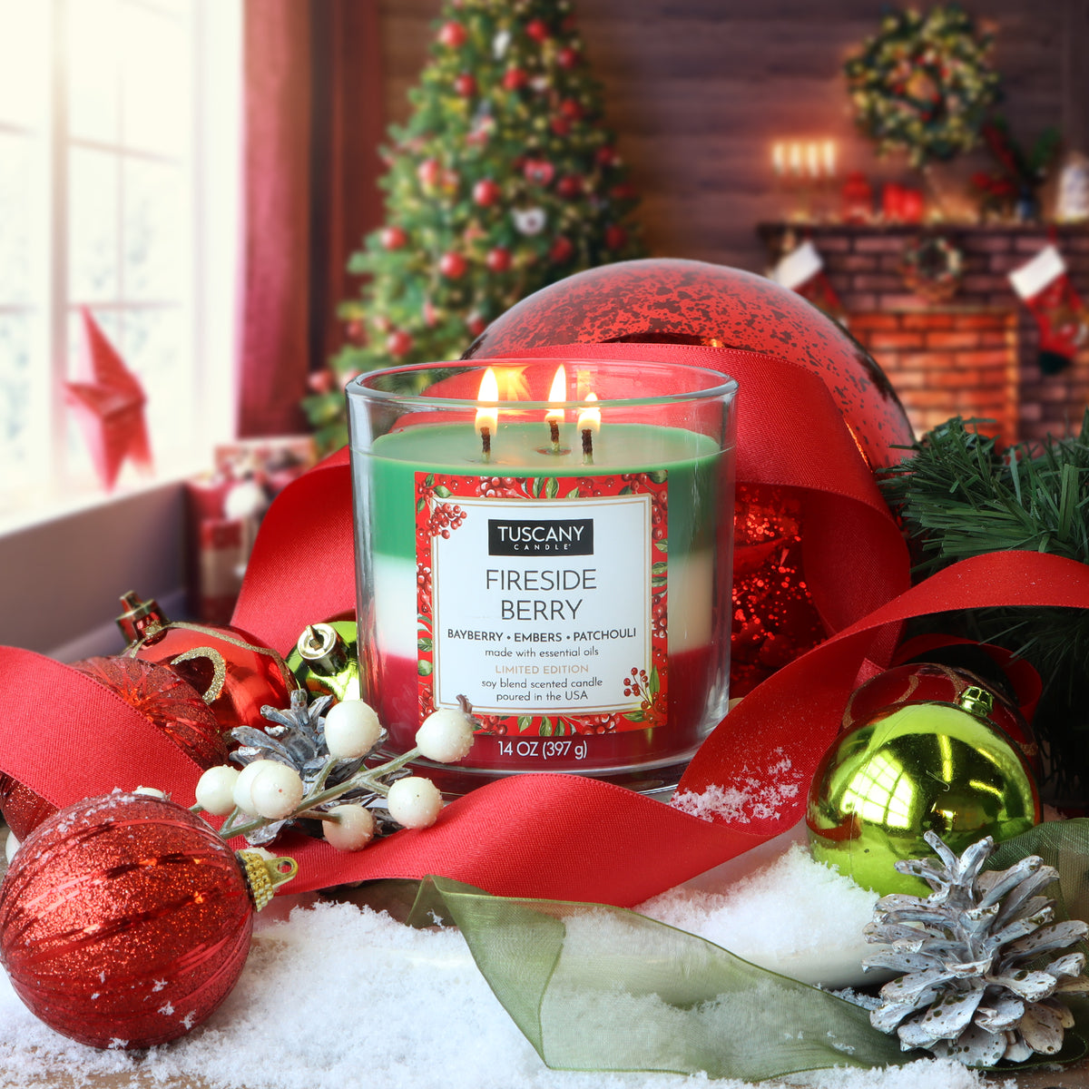 Tuscany Candle® SEASONAL Fireside Berry: Bayberry & Embers Scented Holiday Candle (14 oz) with three wicks and green, white, and red layers, surrounded by red ornaments, ribbons, and pine branches.
