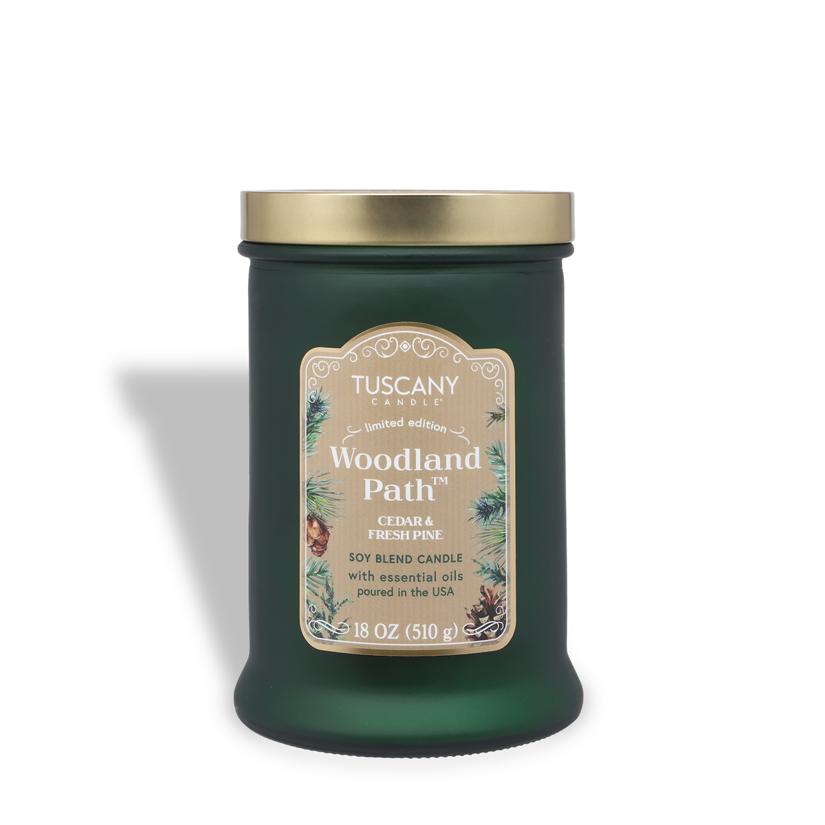 Green glass Woodland Path®: Cedar & Pine Scented Holiday Candle (18 oz) with a gold lid and a decorative label featuring pine branch illustrations.