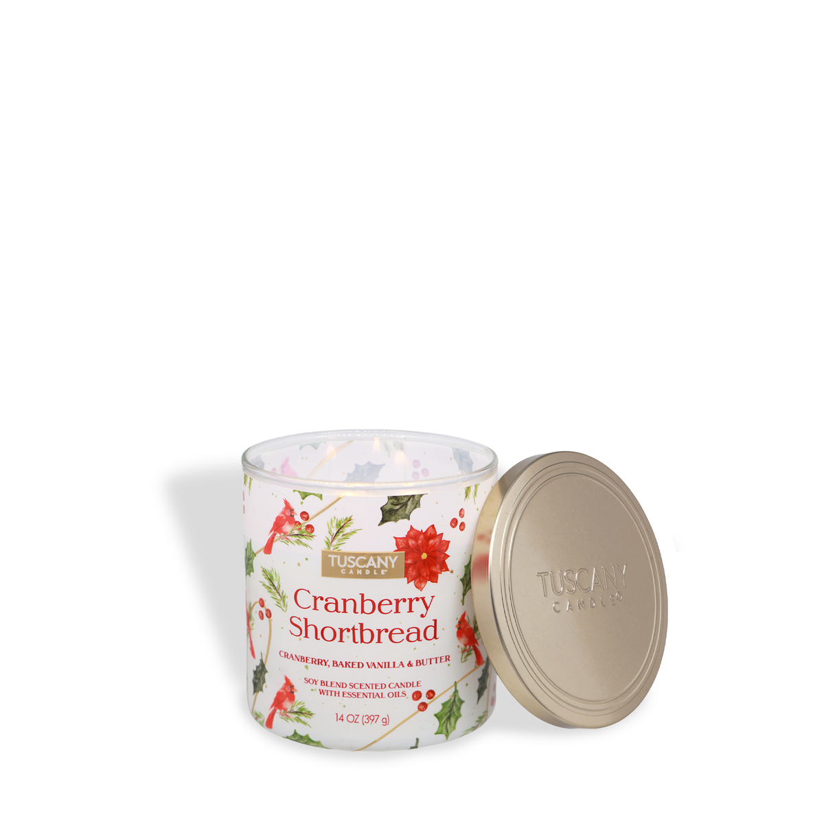 A 14-ounce Tuscany Candle® SEASONAL Cranberry Shortbread: Baked Vanilla & Butter Scented Holiday Candle in a clear glass jar decorated with holiday motifs, shown with its gold metal lid set to the side.