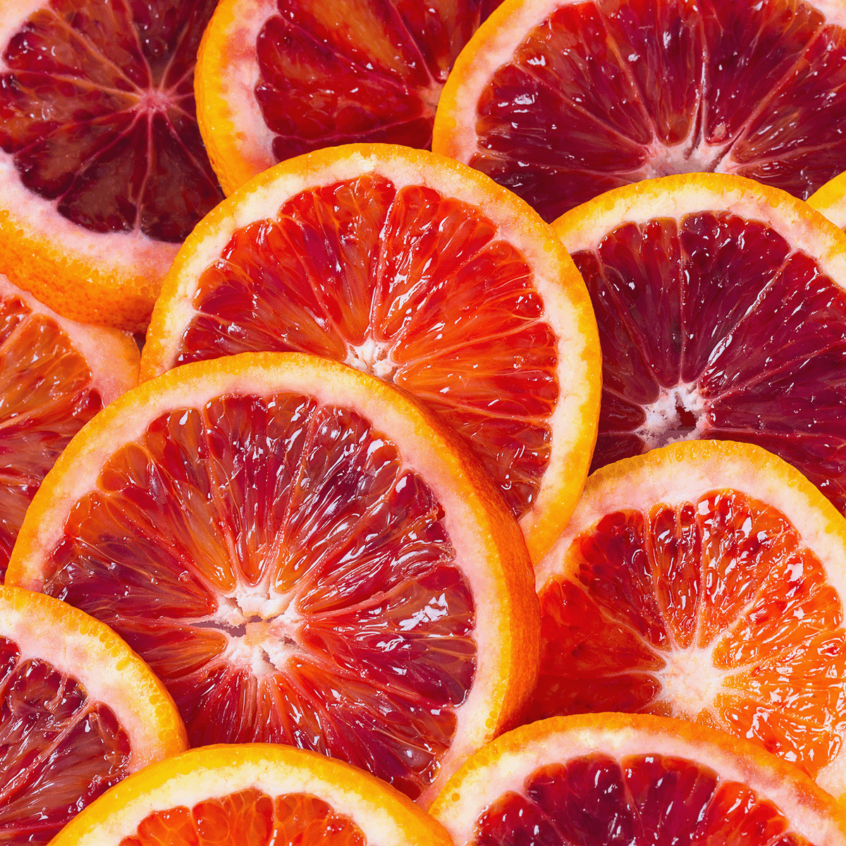 Close-up of overlapping blood orange slices, featured on a Candied Orange Ginger Cookies Scented Holiday Candle (12 oz) by Tuscany Candle® SEASONAL.
