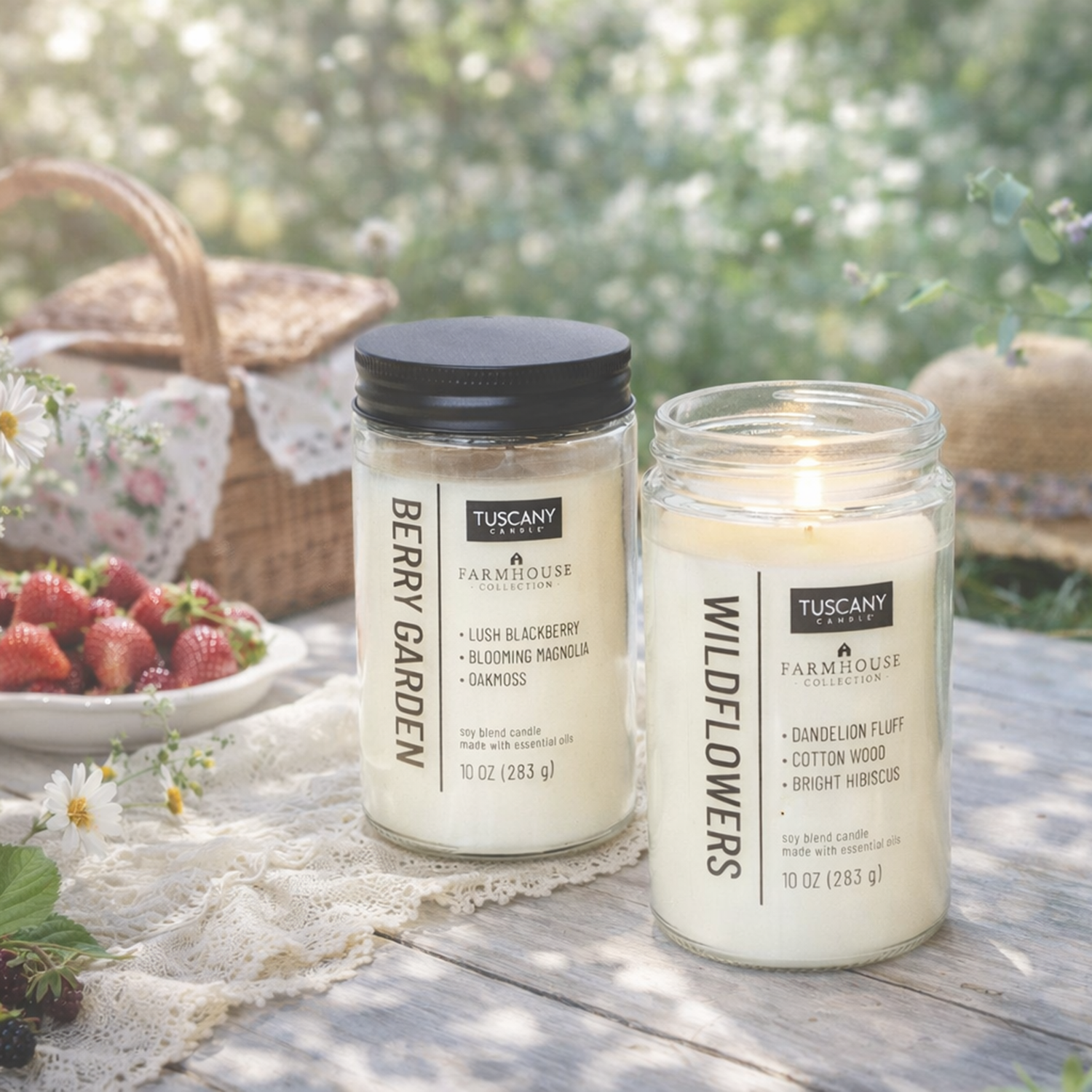 Two Tuscany Candle® EVD Berry Garden Scented Jar Candles (10 oz, Farmhouse Collection) sit on a lace picnic table beside strawberries and wildflowers, adding farmhouse charm to the outdoor scene.