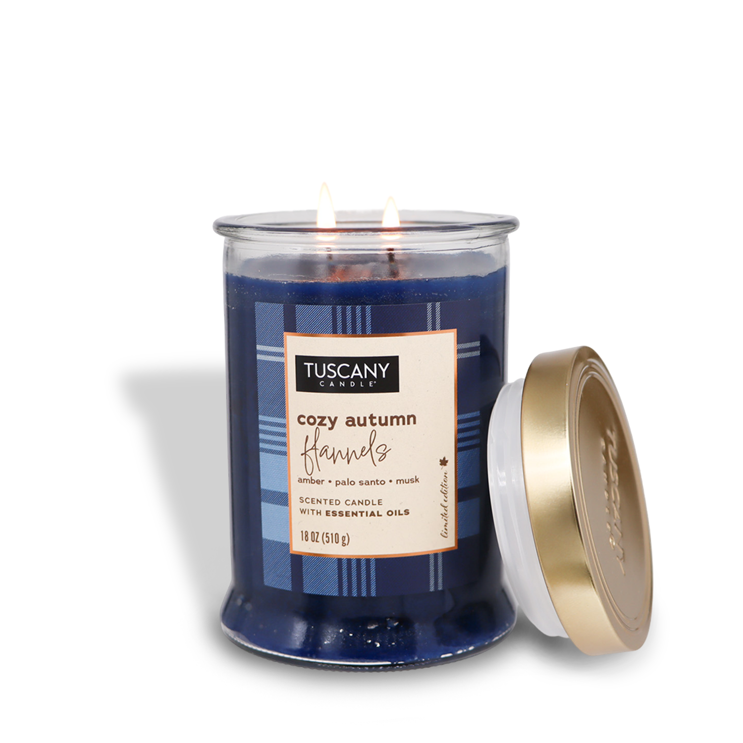 The Tuscany Candle® SEASONAL Cozy Autumn Flannels Long-Lasting Scented Jar Candle (18 oz) from the Autumn Flannels Collection features a rich blend of amber, palo santo, and musk. The blue jar's lid is placed to the side, revealing its double wick design. This fall fragrance candle perfectly encapsulates the cozy essence of autumn.