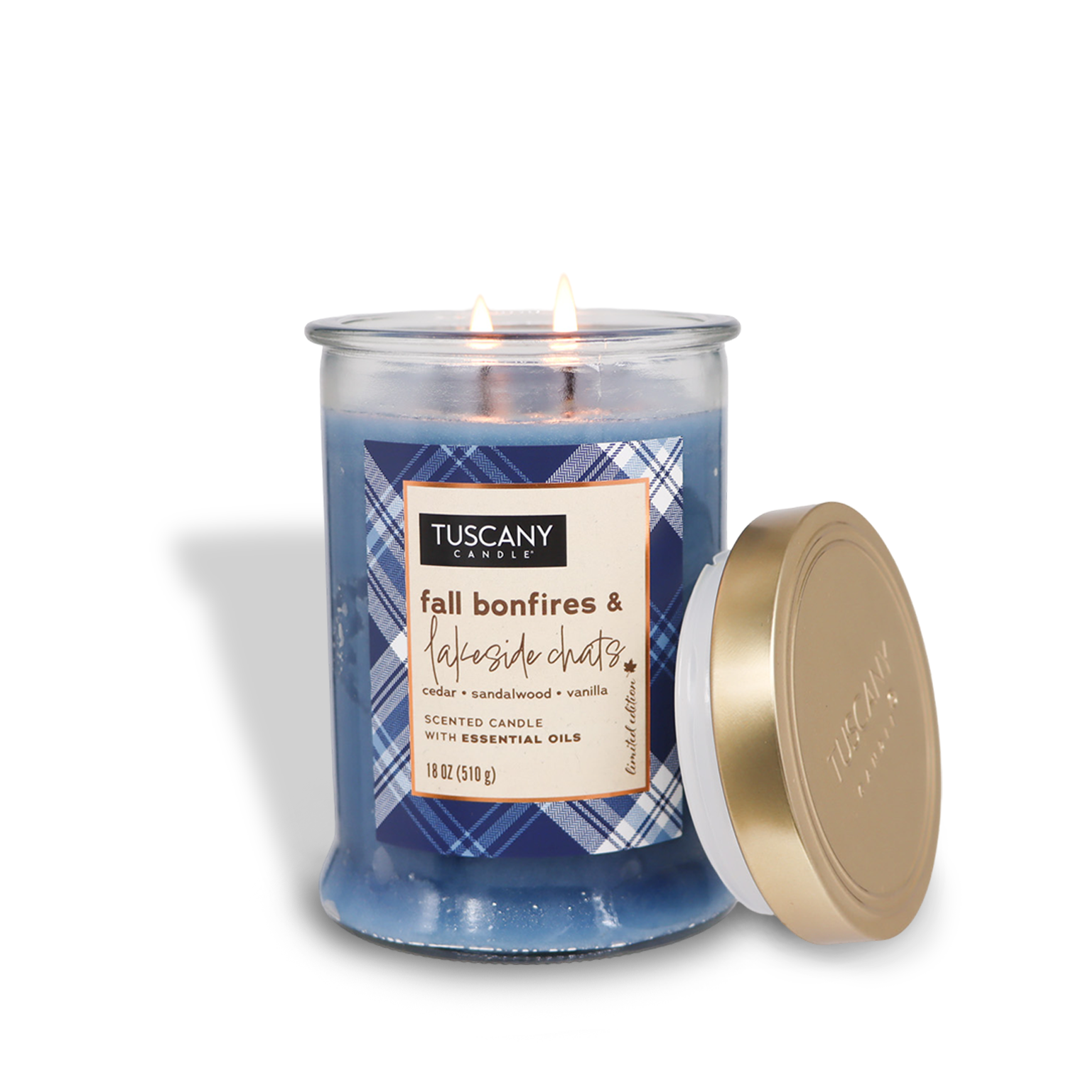 The Tuscany Candle® SEASONAL Fall Bonfires & Lakeside Chats Long-Lasting Scented Jar Candle (18 oz) — part of the Autumn Flannels Collection, features cedar and sandalwood fragrances with a hint of vanilla. This blue autumn candle comes in a glass jar with a gold lid placed beside it.