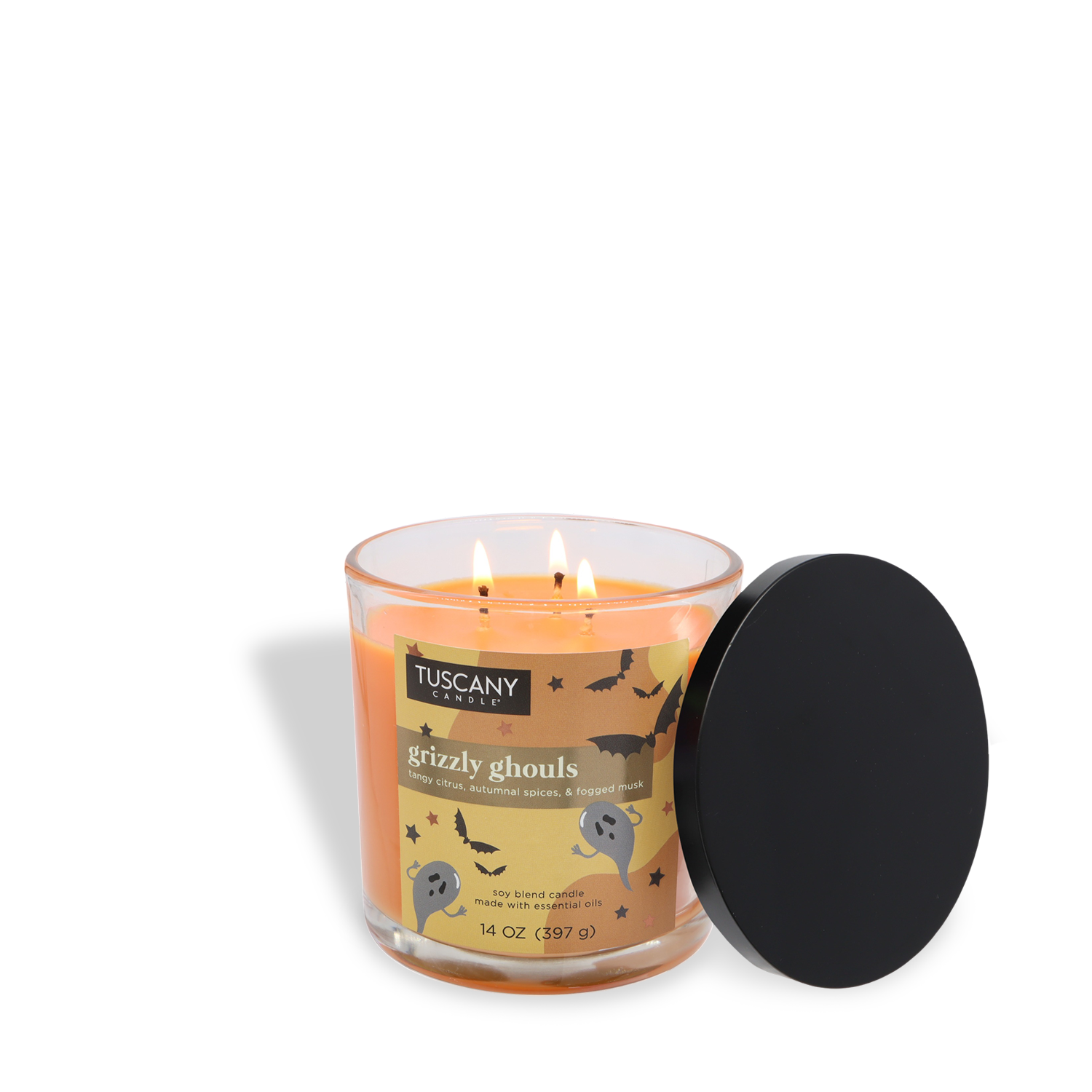 A lit 14 oz Tuscany Candle® SEASONAL "Grizzly Ghouls: Autumnal Spices & Fogged Musk" Halloween candle sits beside its black lid, featuring a festive design.