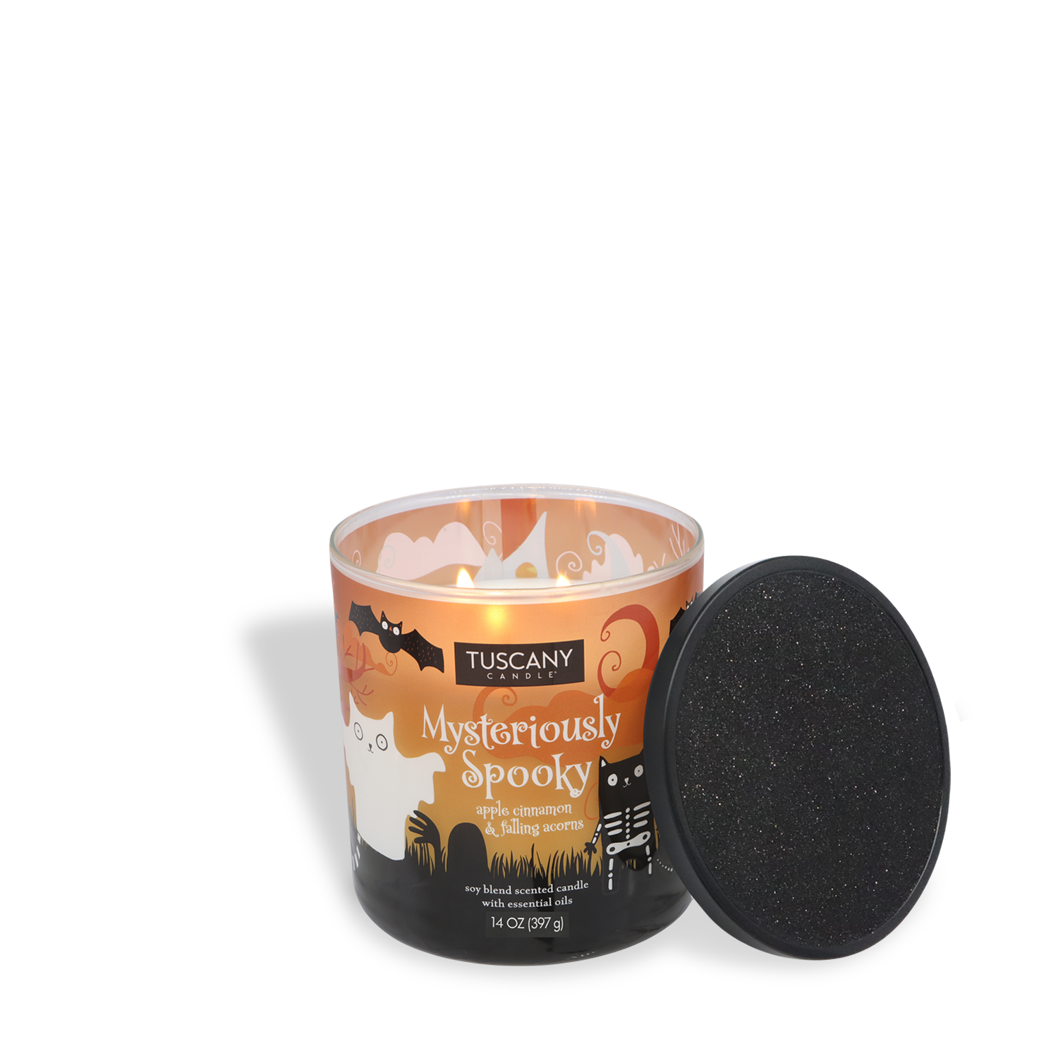 A lit Tuscany Candle® SEASONAL "Mysteriously Spooky: Apple Cinnamon & Amber" (14 oz) from the Mysteriously Spooky Collection sits by its glittery black lid, featuring a Halloween-themed glass design.