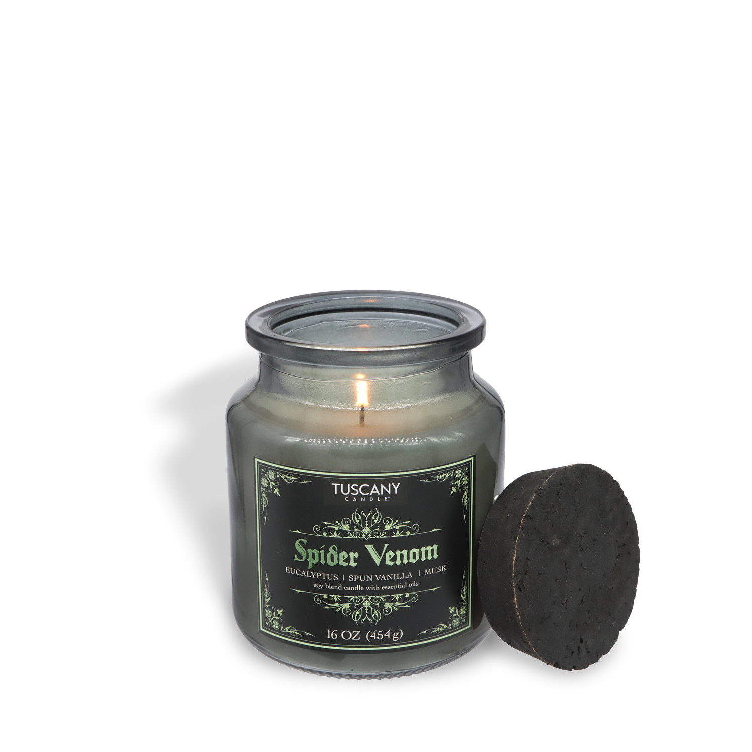 A lit Tuscany Candle® SEASONAL Spider Venom: Chilling Eucalyptus & Spun Vanilla Halloween Candle (16 oz) from the Apothecary Collection glows, its black lid resting beside the jar, filling the air with eucalyptus, vanilla, and musk.