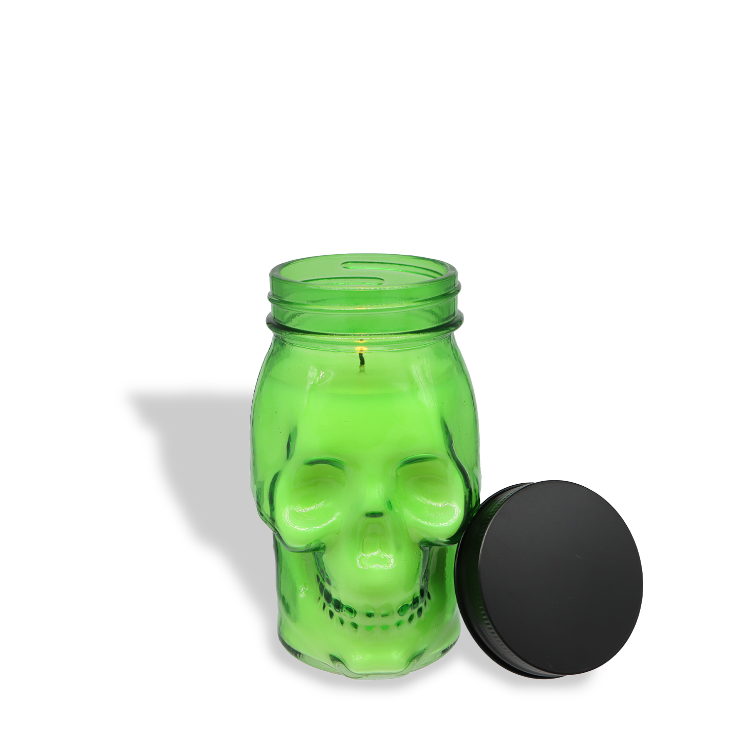 The Enchanted Oakmoss: Smoky Incense & Creeping Oakmoss Scented Halloween Candle (12 oz) from Tuscany Candle® SEASONAL features a green soy blend in a skull-shaped glass jar with a black lid—perfect for spooky décor.