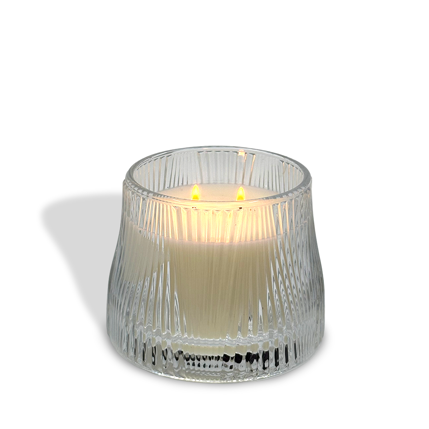 The est.1951 Linen & Pomelo Grove (9oz) luxury candle features three wicks in a ribbed clear glass container, crafted from vegan wax and infused with a refreshing citrus scent.