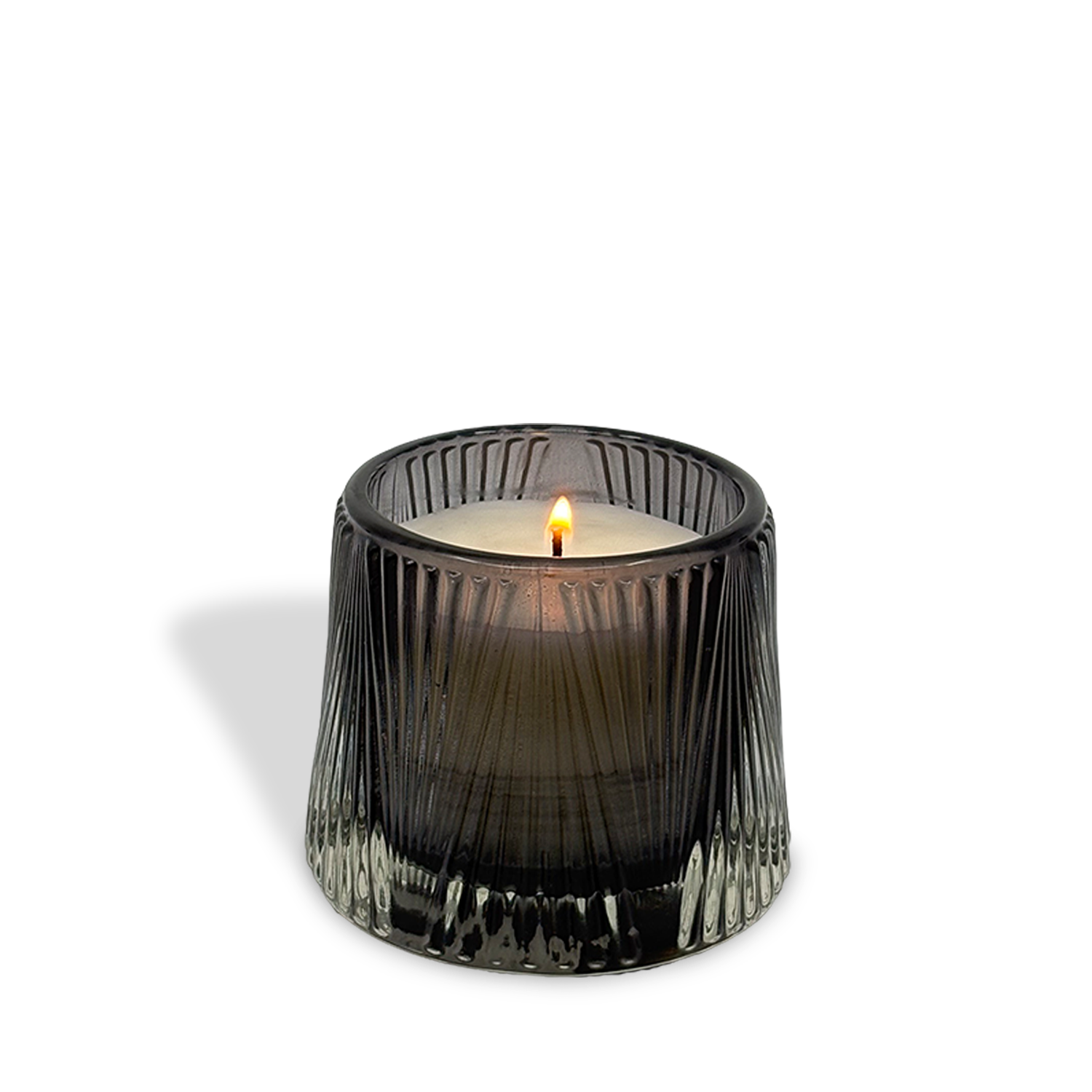 The est.1951 Bergamot & Musk (4oz) candle, in a textured dark glass holder, is lit and placed against a white background, casting a faint shadow to the left.