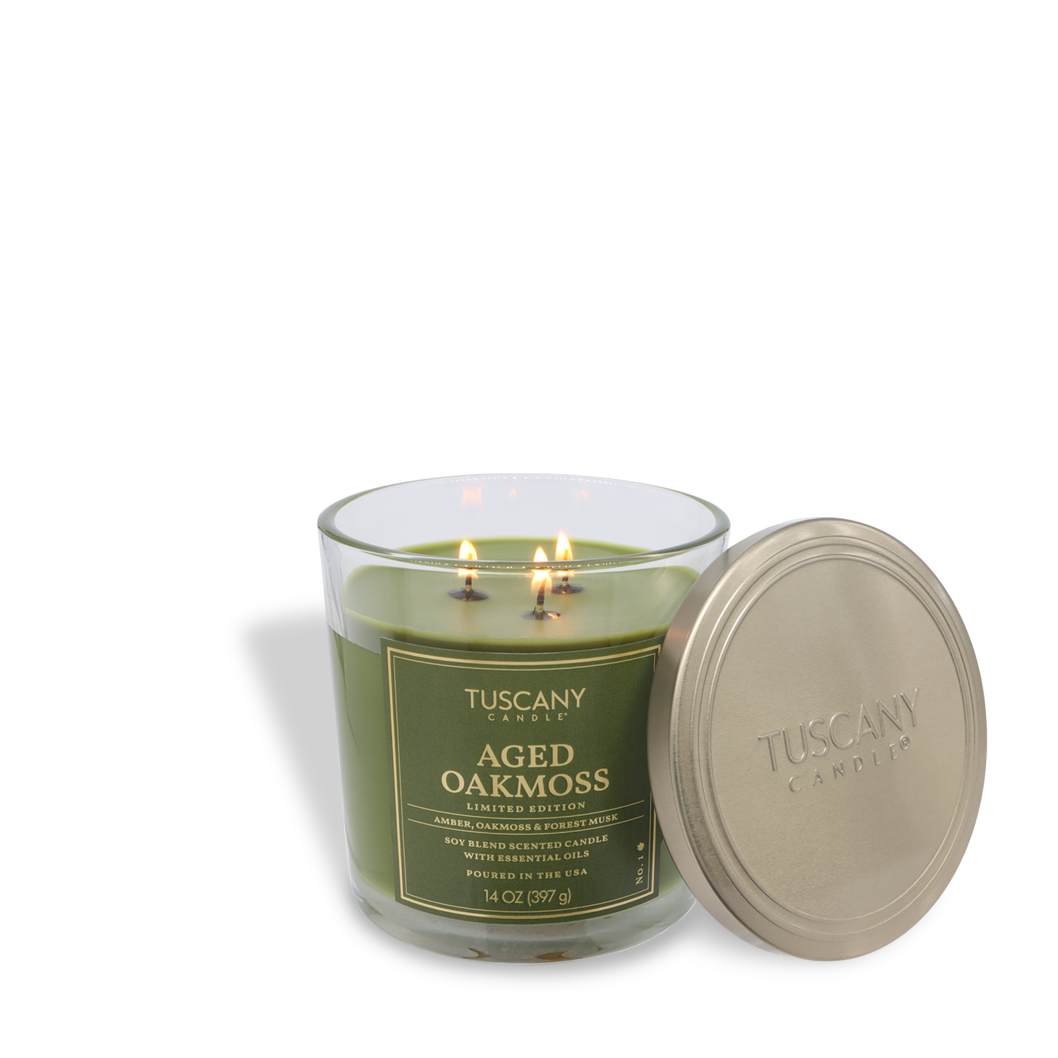 A Tuscany Candle® SEASONAL "Aged Oakmoss: Forest Musk & Amber" 14 oz candle with two lit wicks and a gold lid beside its green glass jar.